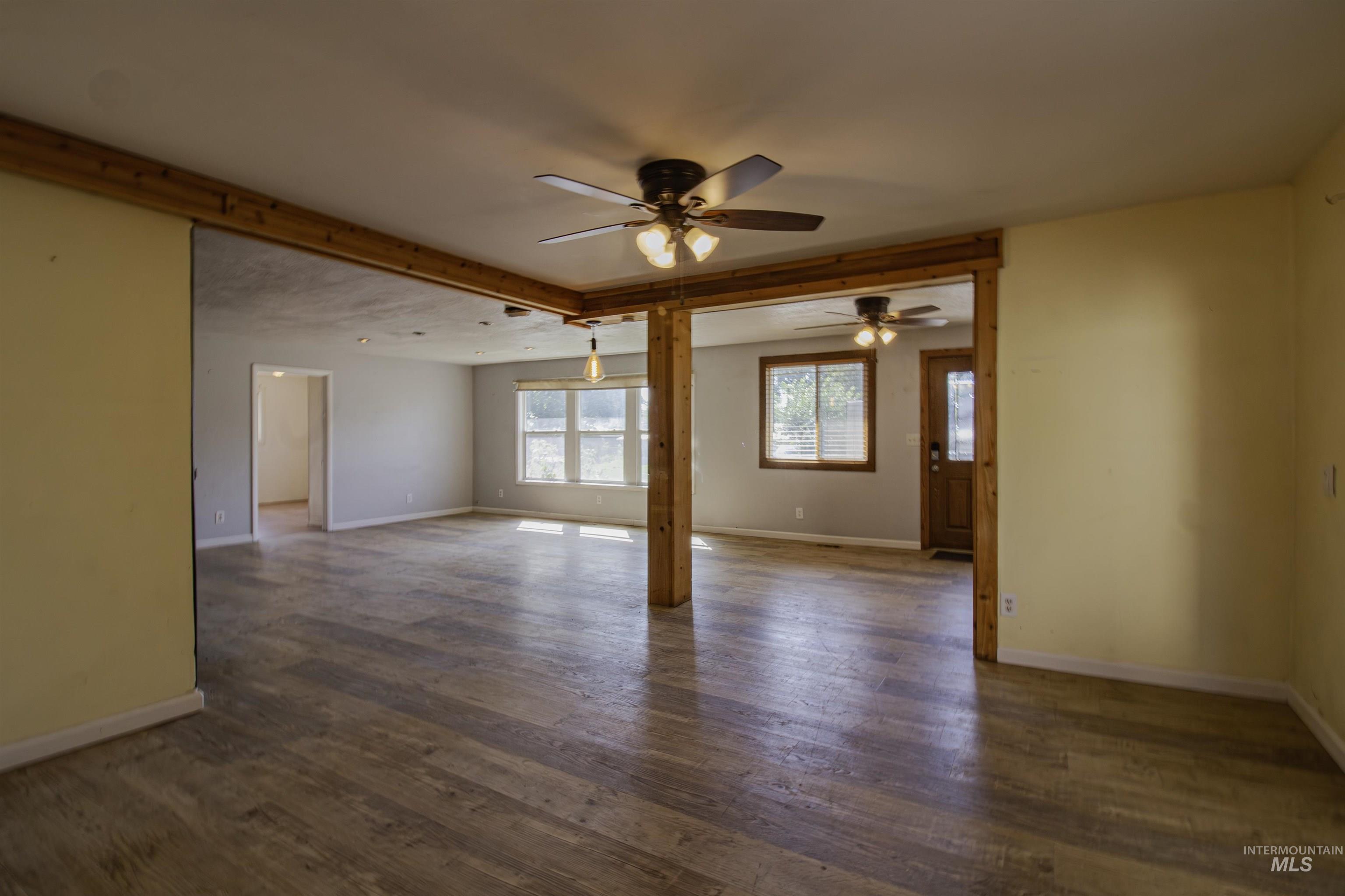 Spare room featuring dark wood-style flooring and a ceiling fan