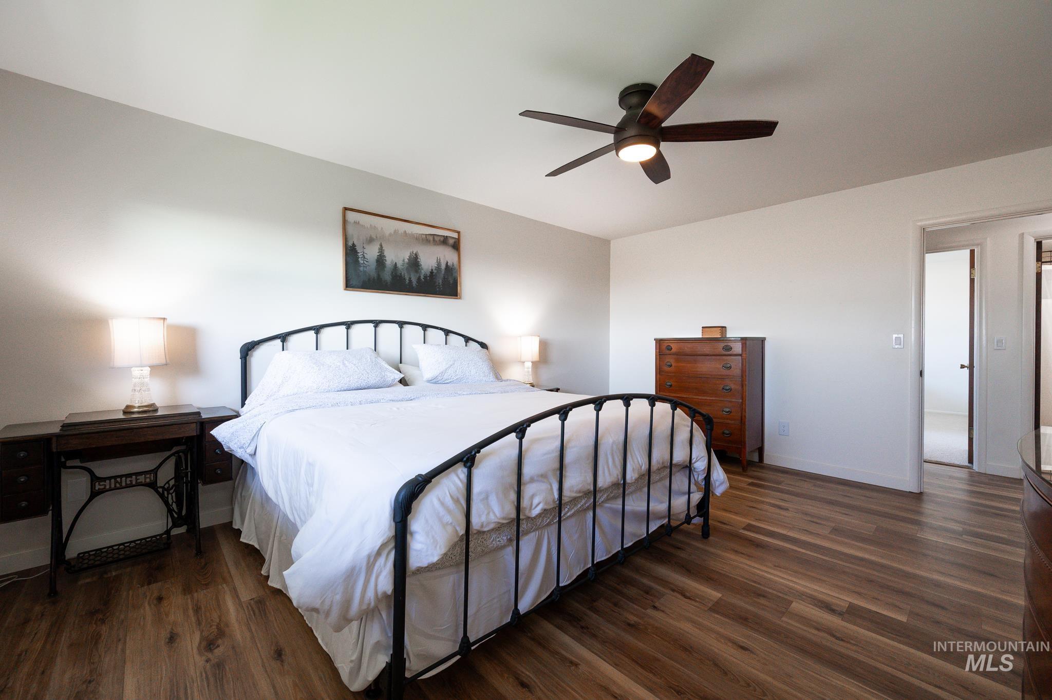 Bedroom with dark wood-style flooring and ceiling fan