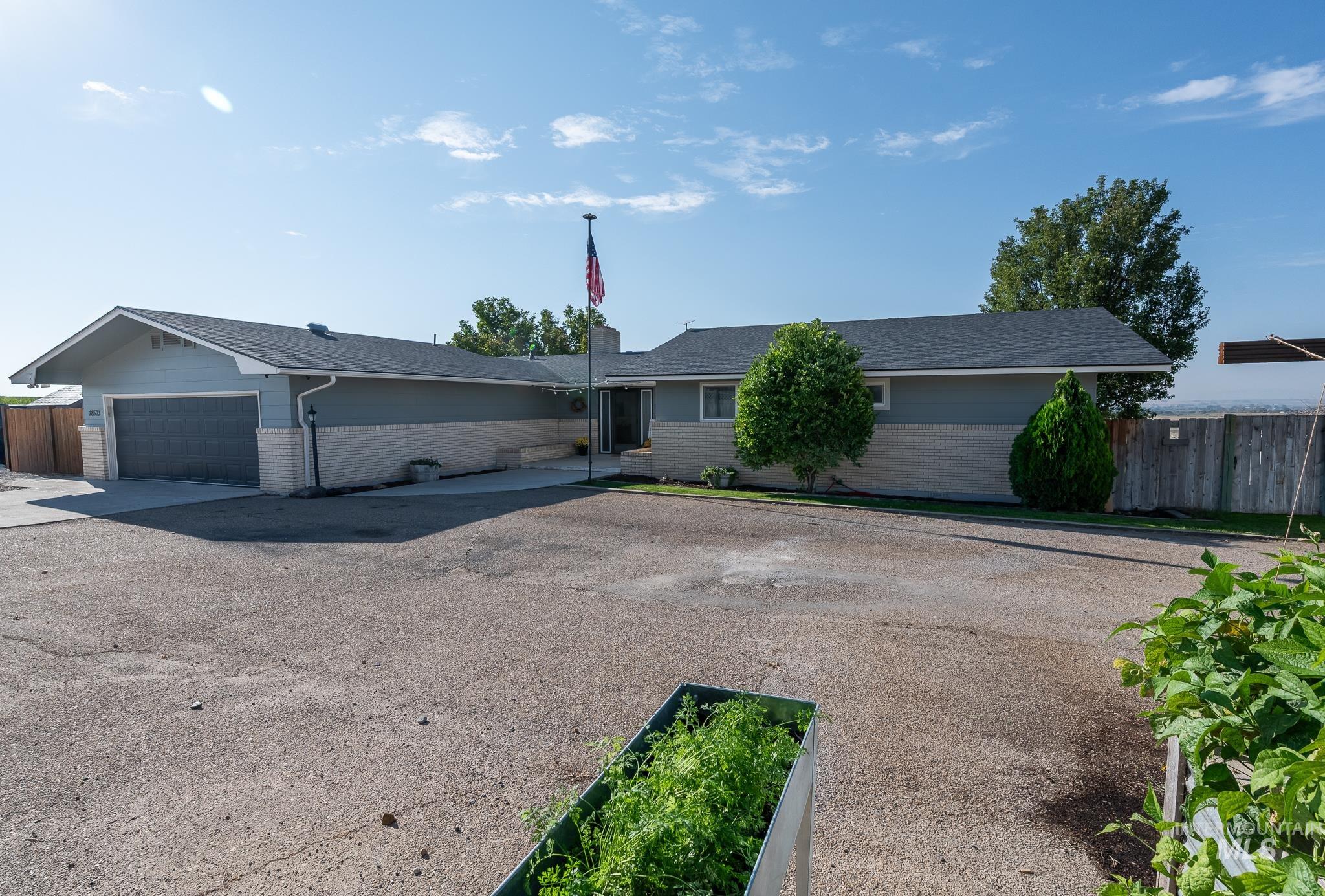 Ranch-style home with brick siding, driveway, an attached garage, and roof with shingles