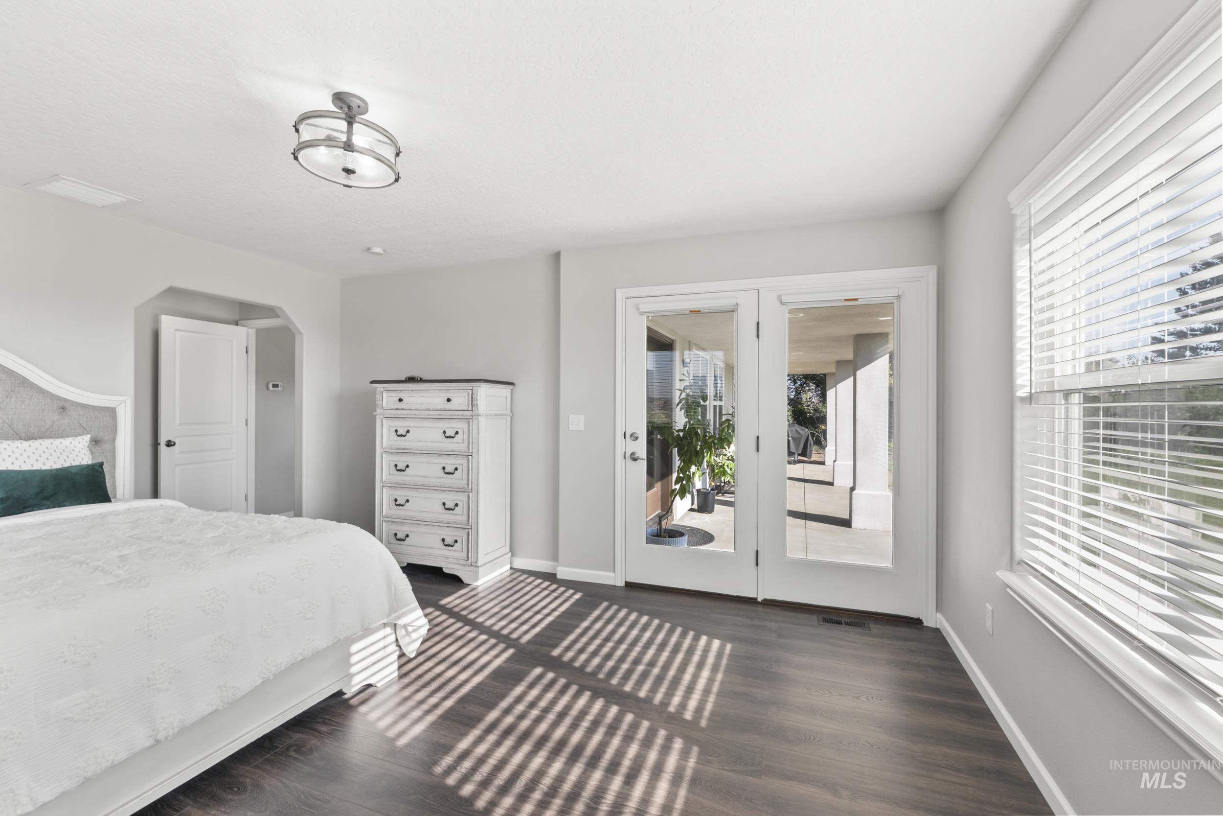 Bedroom with access to exterior and dark wood-style flooring