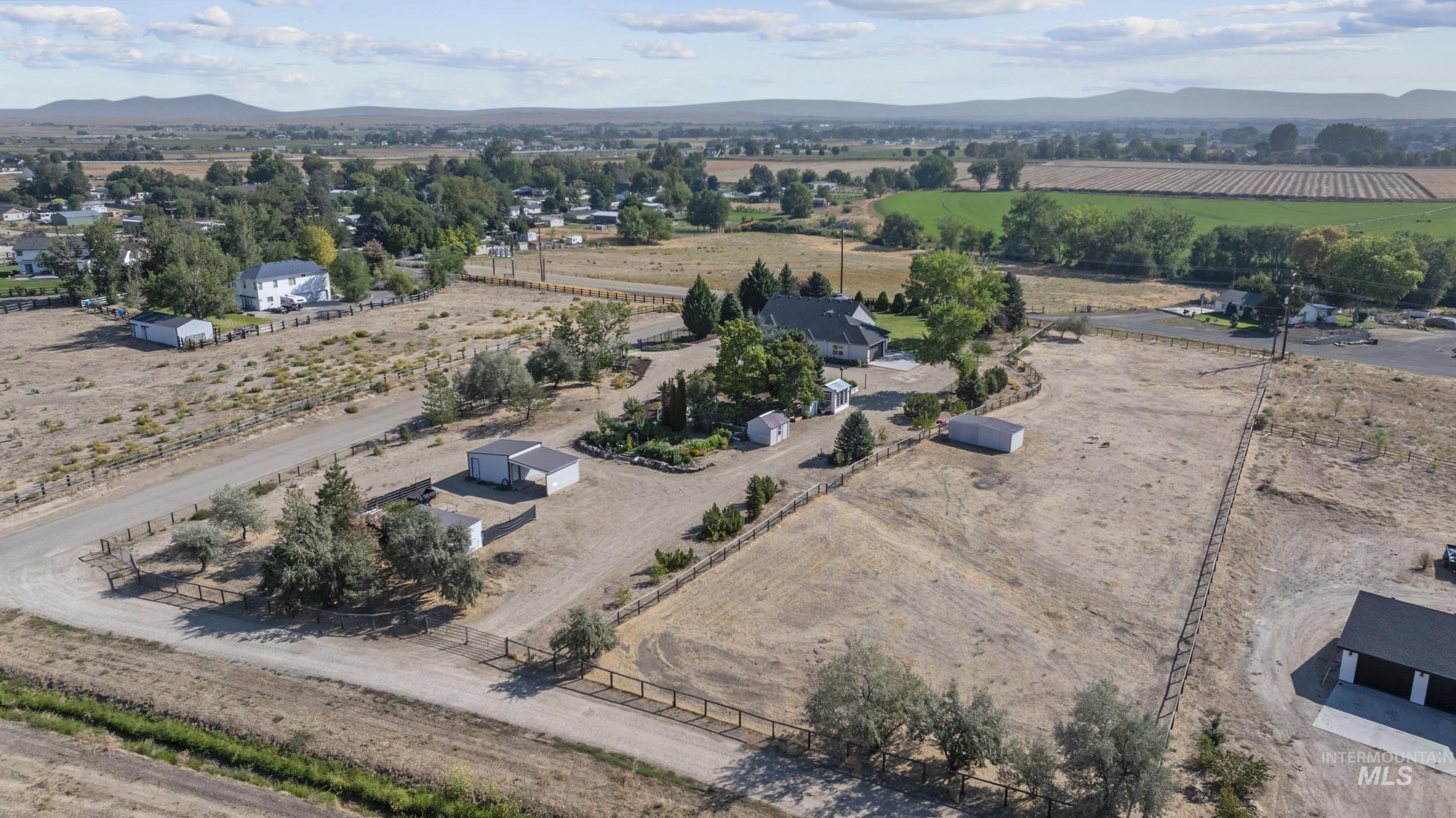 Overview of rural landscape featuring a mountain backdrop and rows of crops