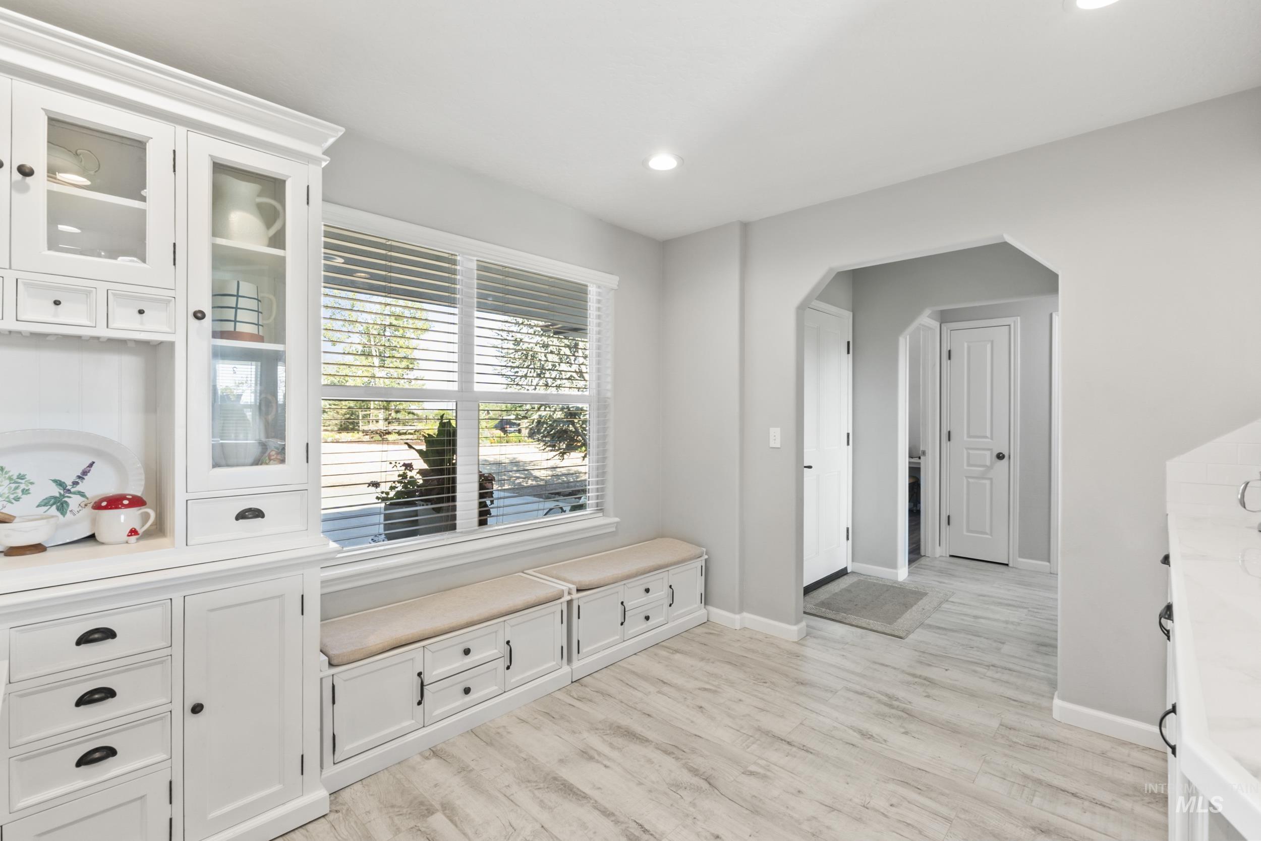 Mudroom with light wood finished floors, arched walkways, and recessed lighting
