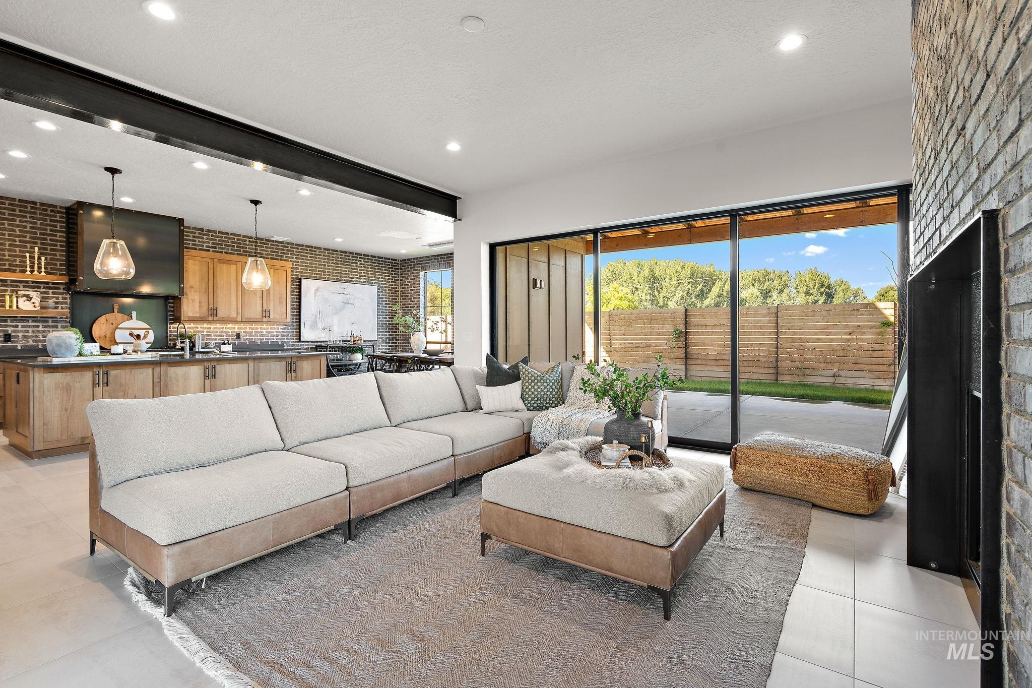 Living area with brick wall, healthy amount of natural light, light tile patterned floors, a fireplace, and recessed lighting