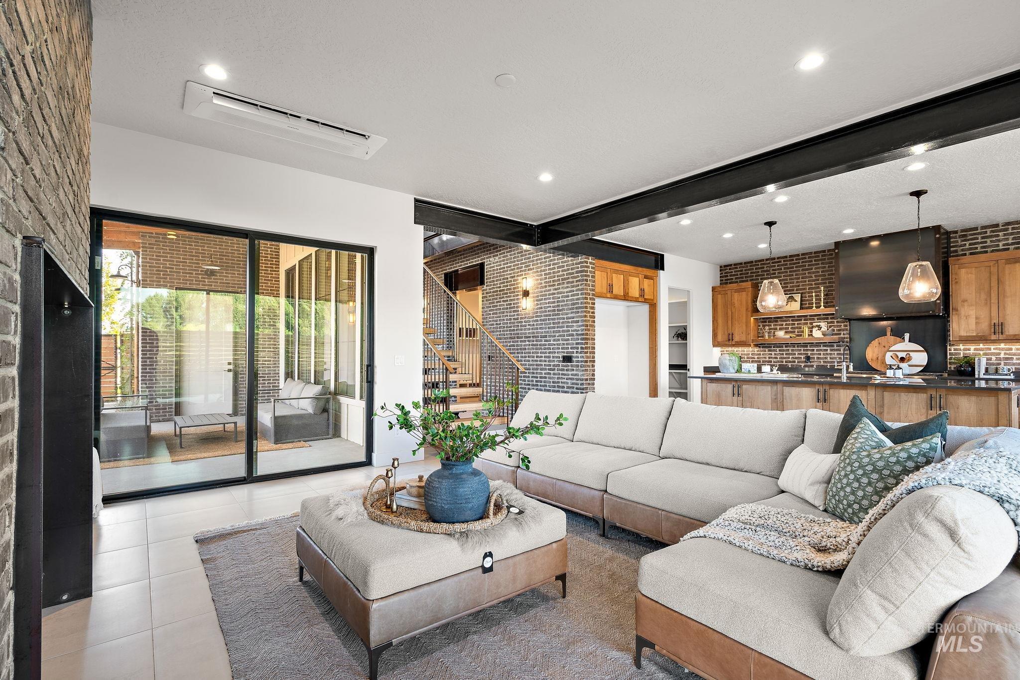 Living room featuring beam ceiling, recessed lighting, tile patterned flooring, and brick wall