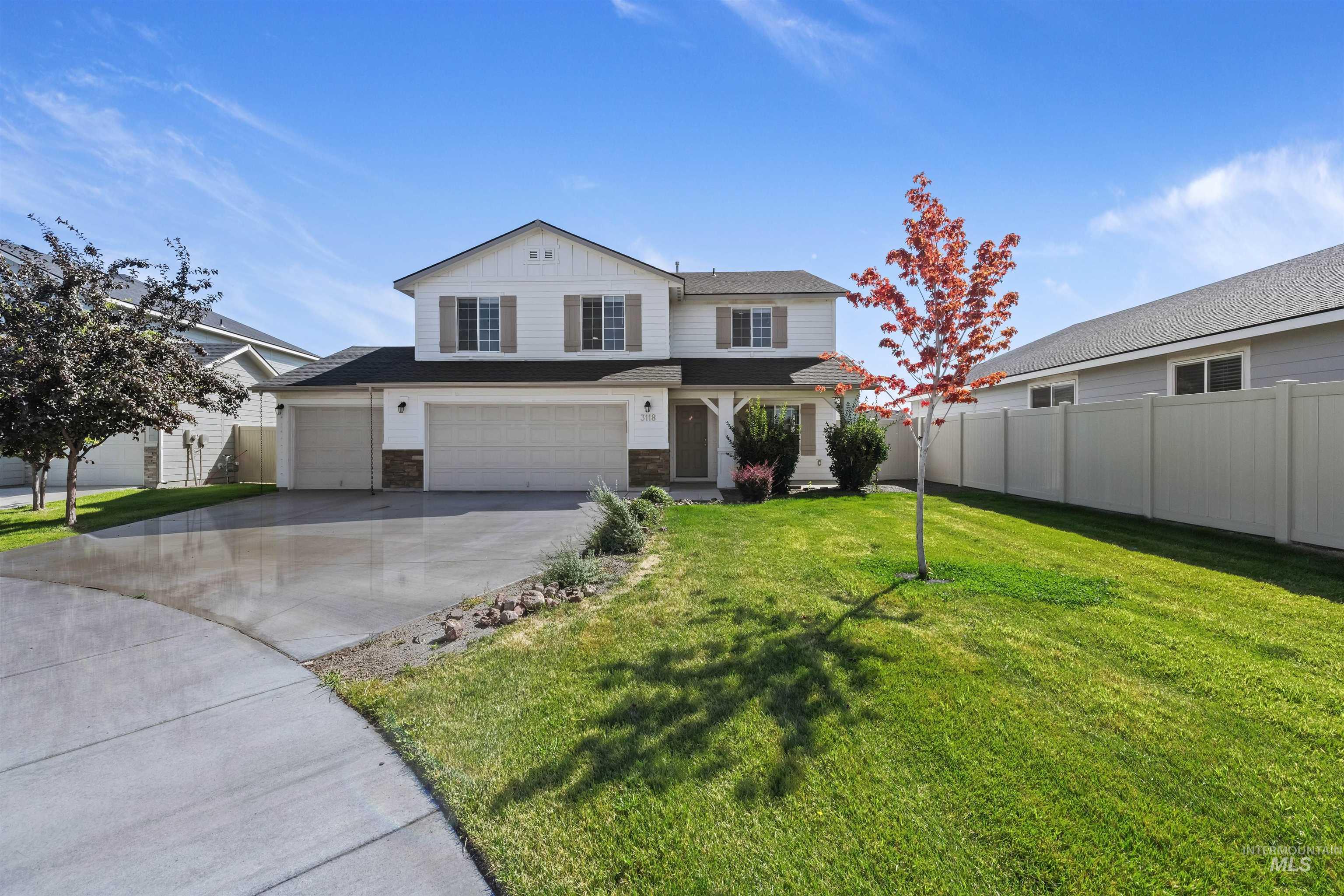 Traditional home with driveway, a garage, and stone siding