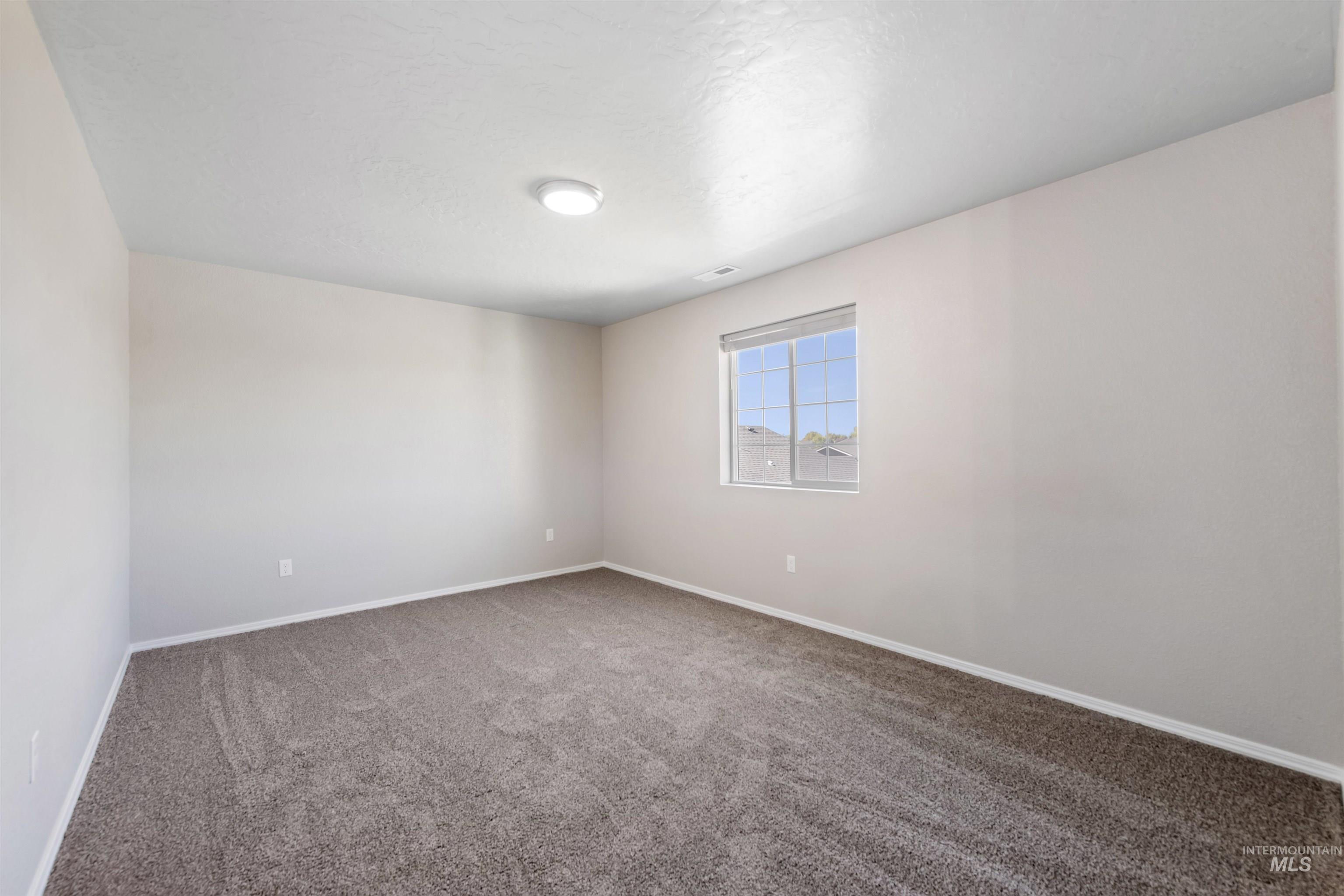 Carpeted empty room with baseboards