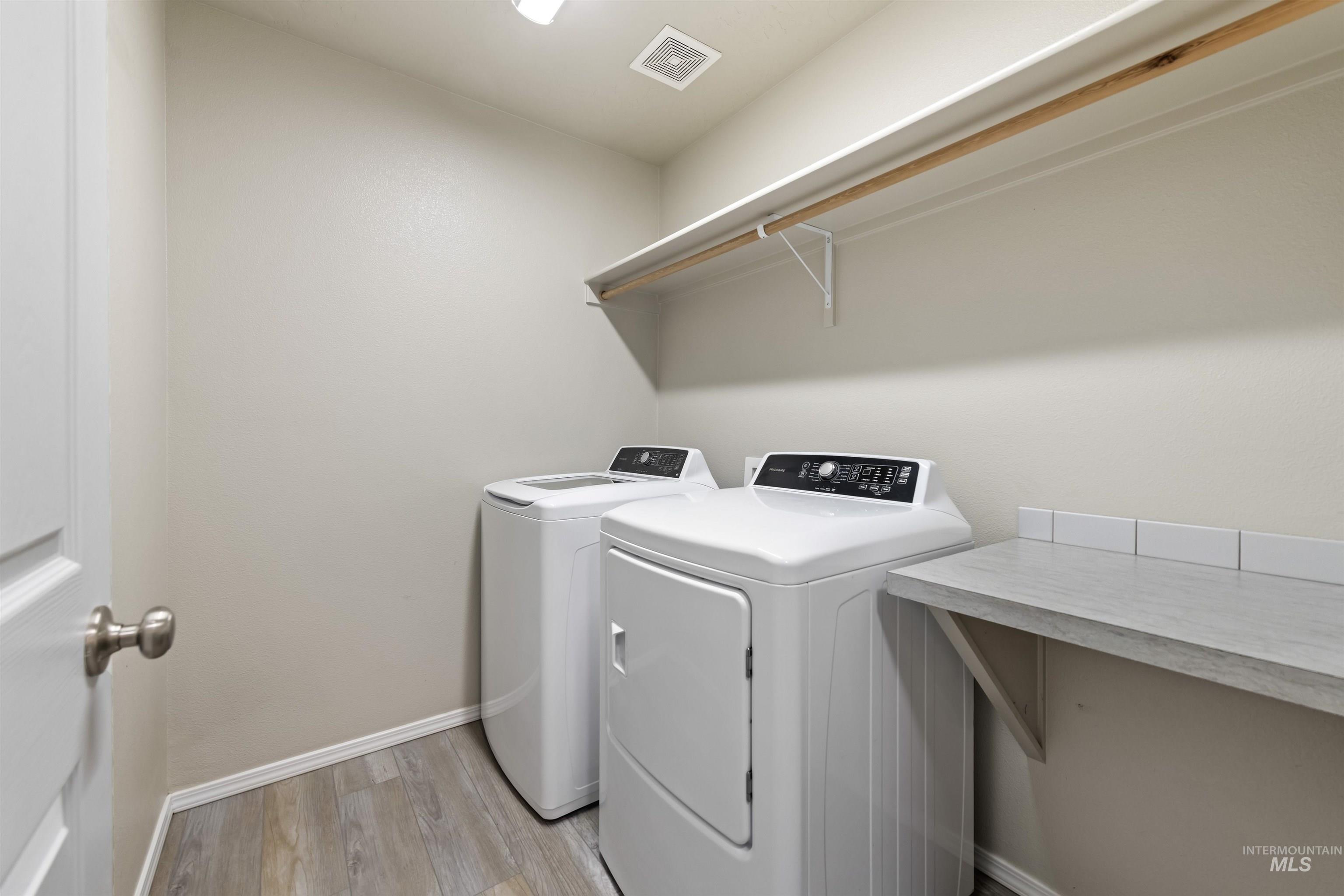Washroom featuring light wood-type flooring and independent washer and dryer