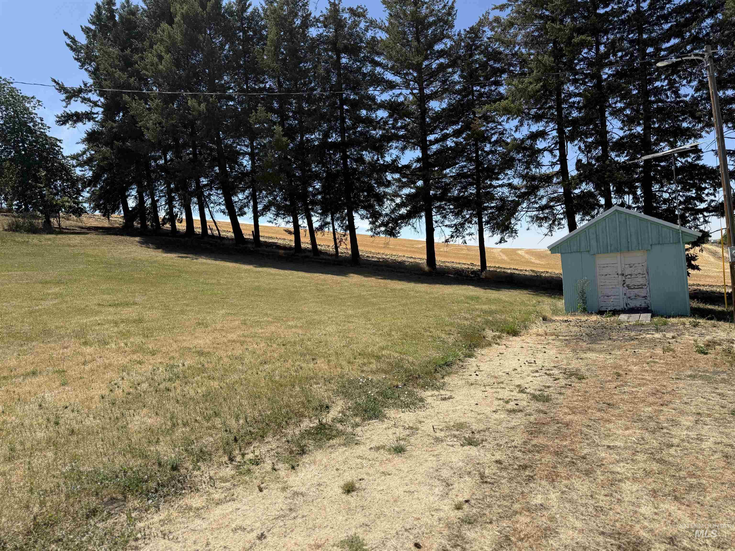 View of green lawn with a shed and a view of rural / pastoral area
