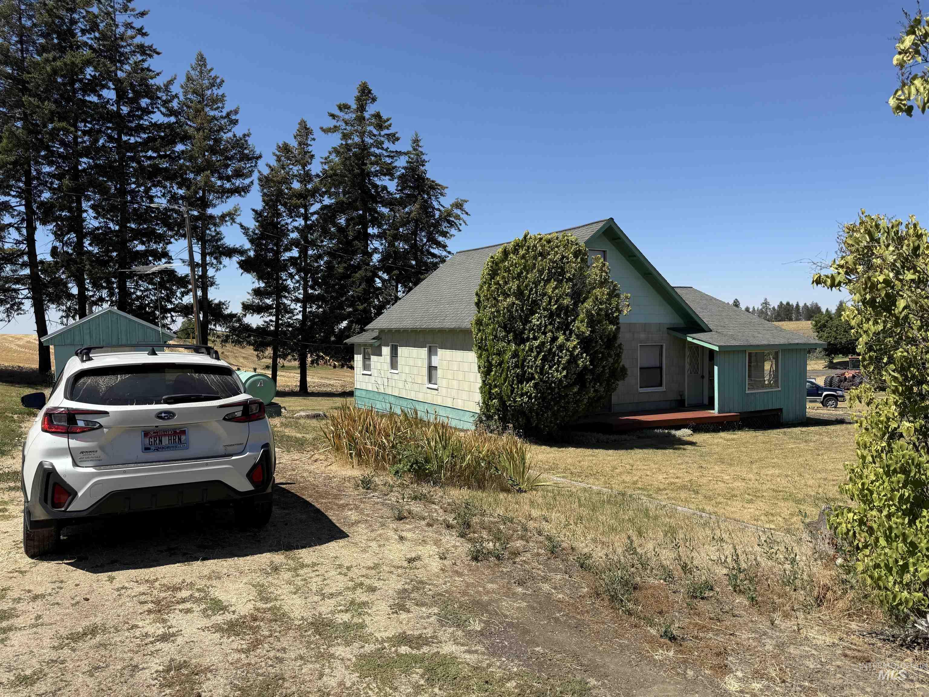View of property exterior with a yard and a shingled roof