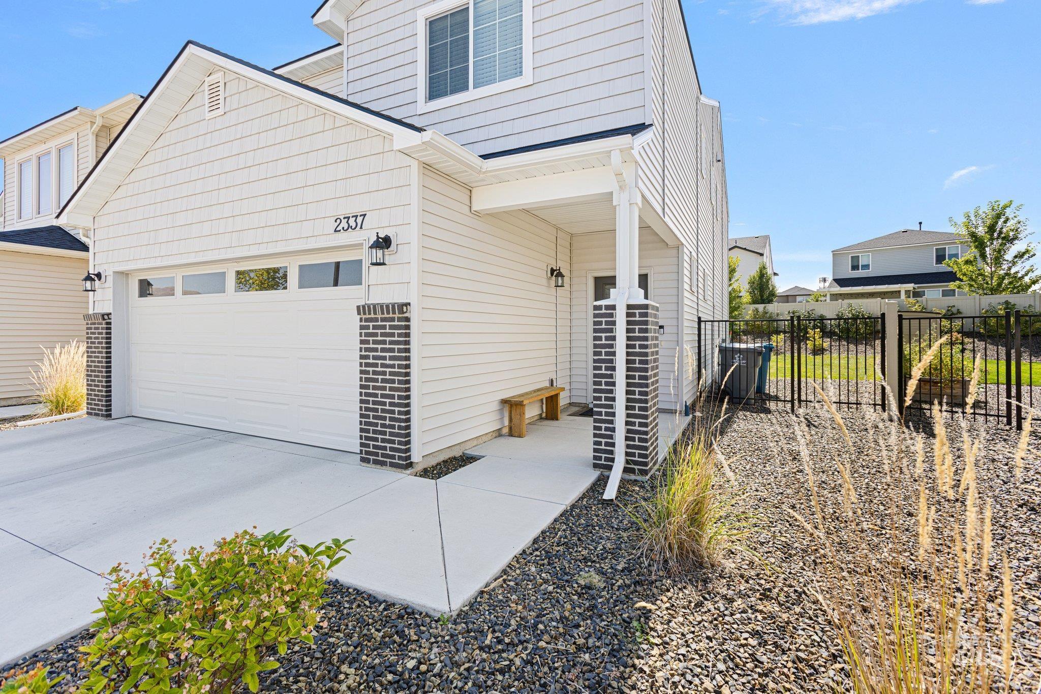 View of side of property featuring concrete driveway and a garage