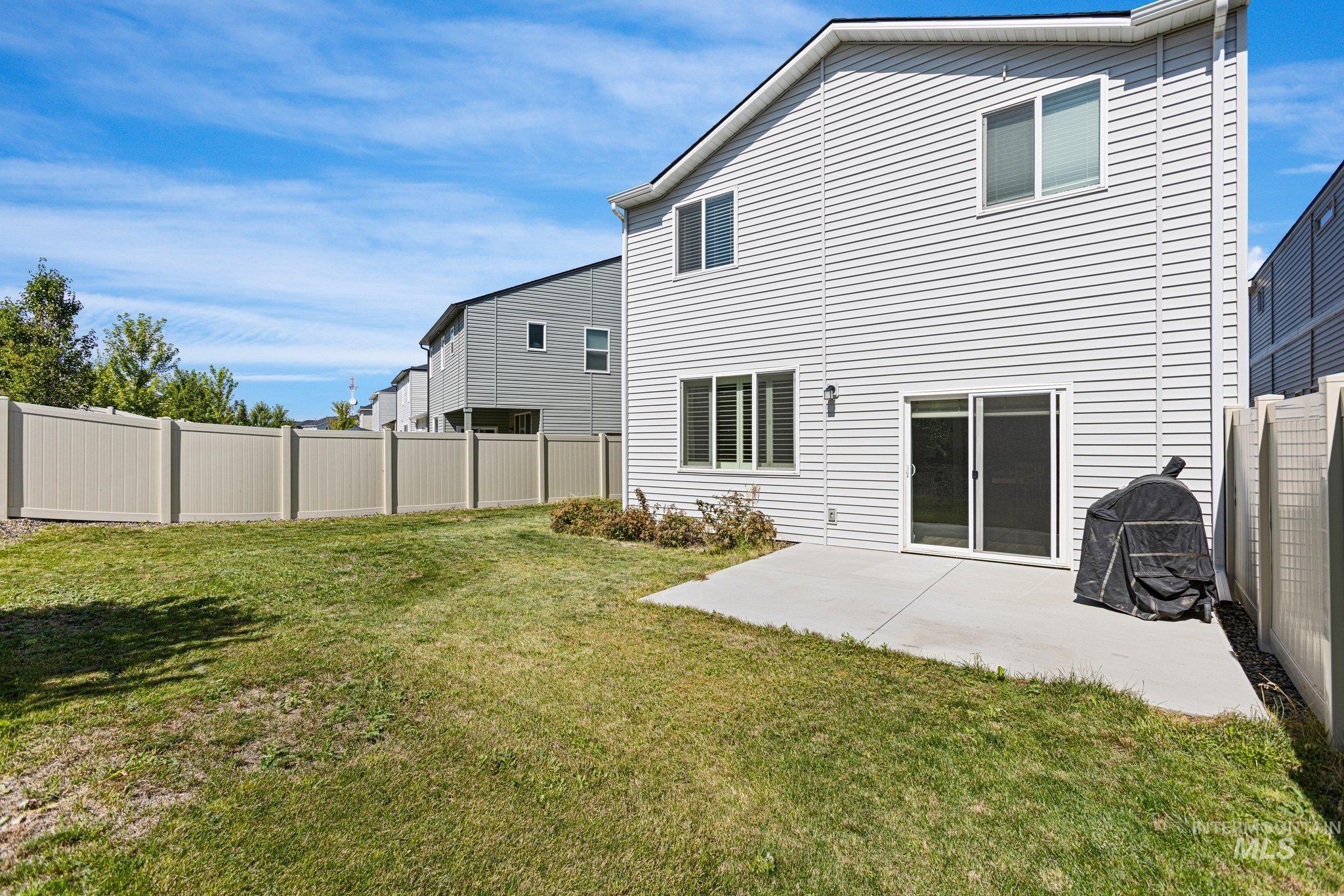 Back of property featuring a fenced backyard and a patio area