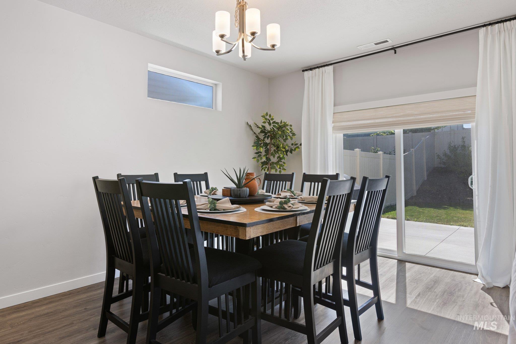 Dining area featuring dark wood finished floors and a chandelier