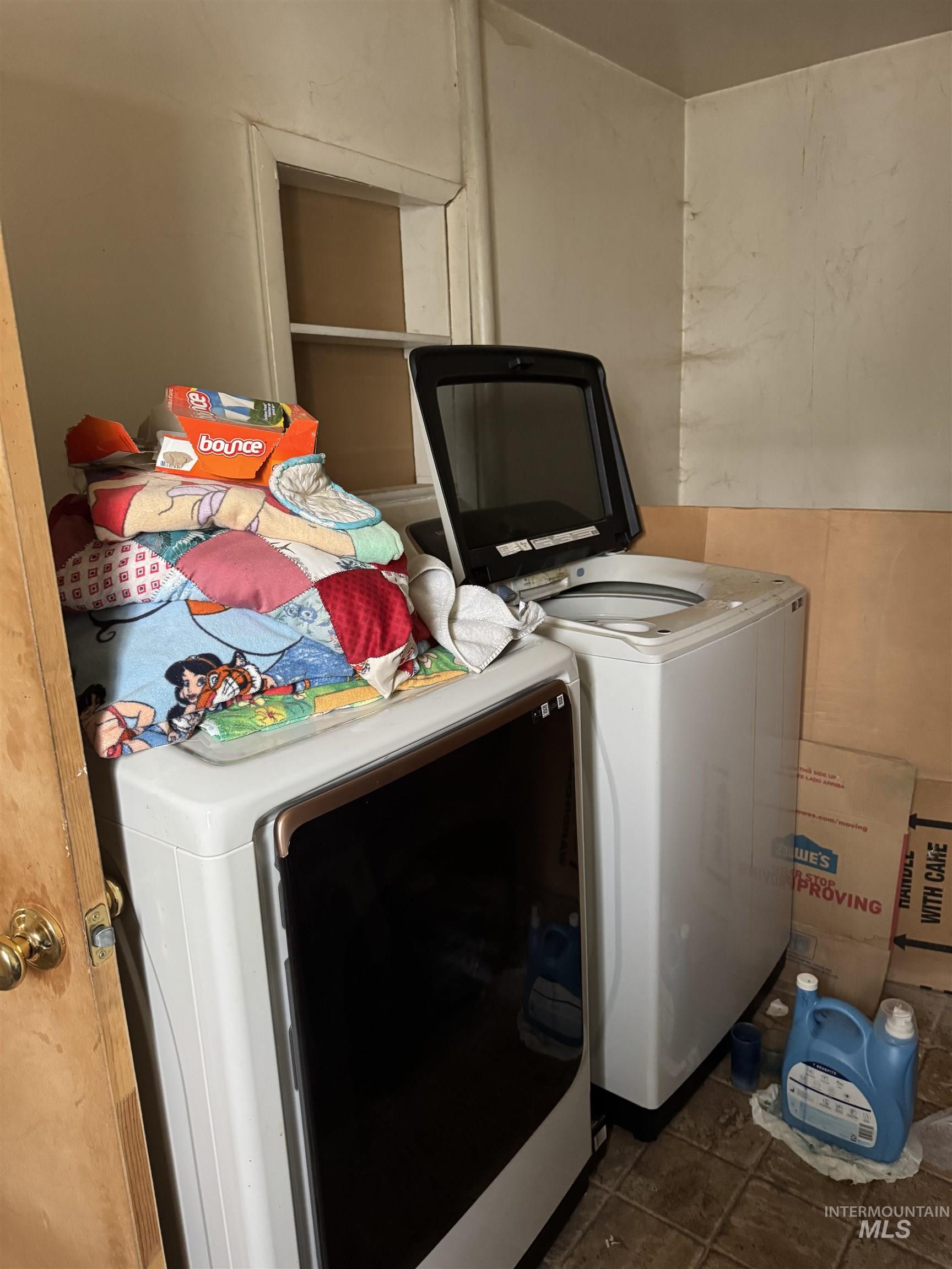 Laundry room featuring washing machine and clothes dryer and dark tile patterned floors