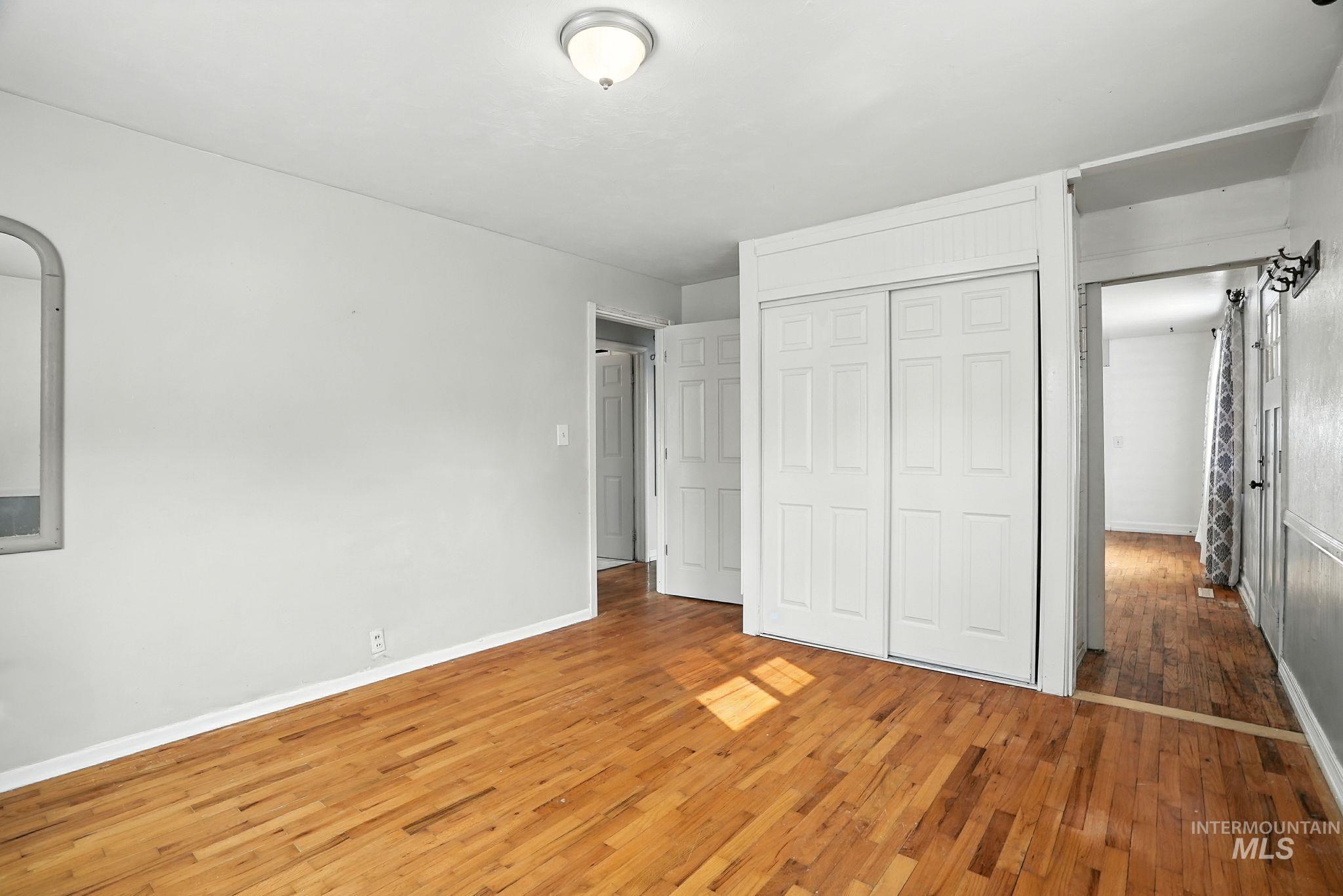 Unfurnished bedroom with light wood-type flooring and a closet