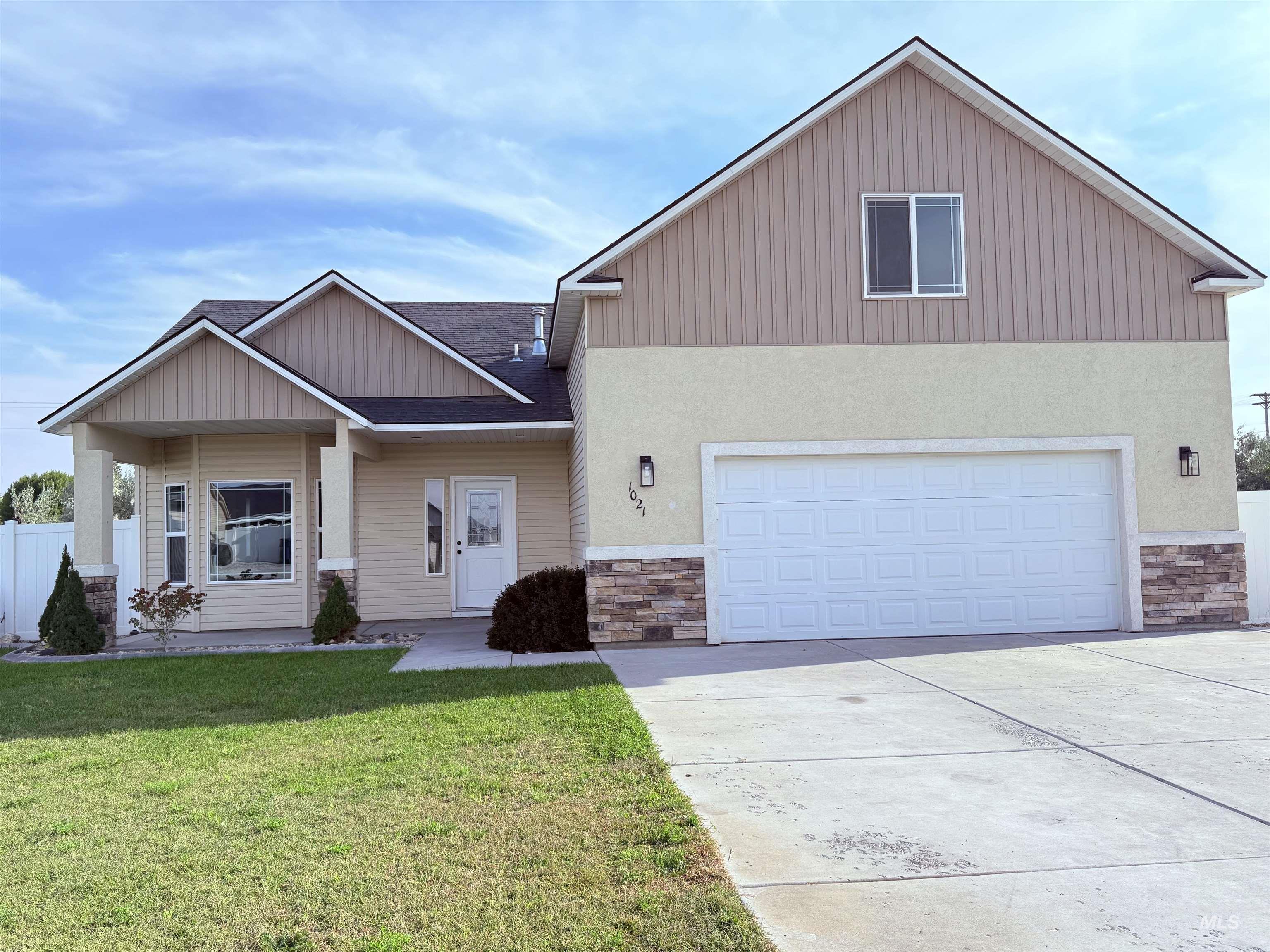Craftsman inspired home featuring stone siding, a front yard, concrete driveway, and a garage