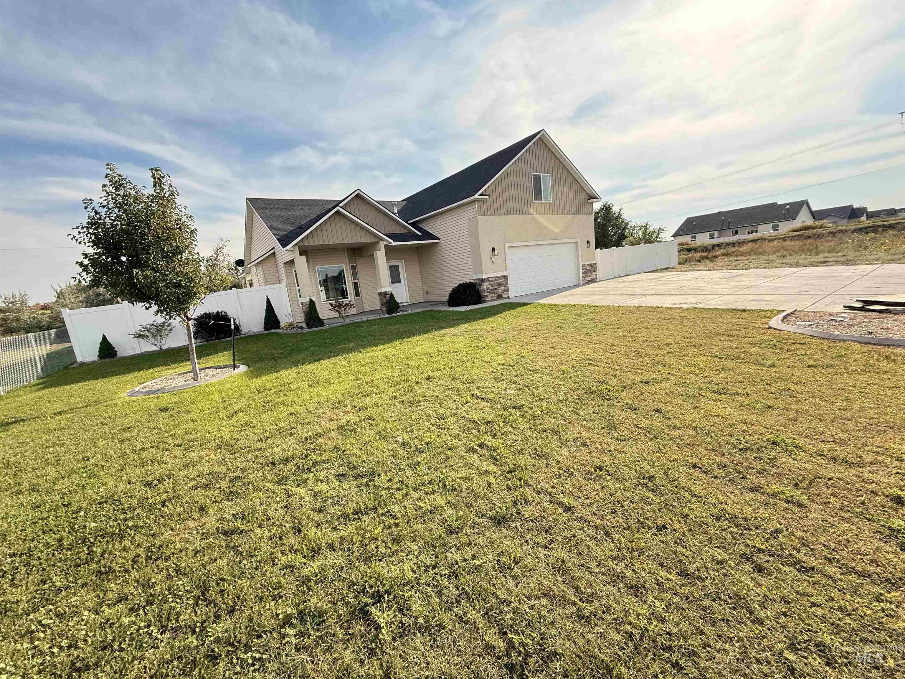 View of front of home featuring stone siding, driveway, covered porch, and a garage