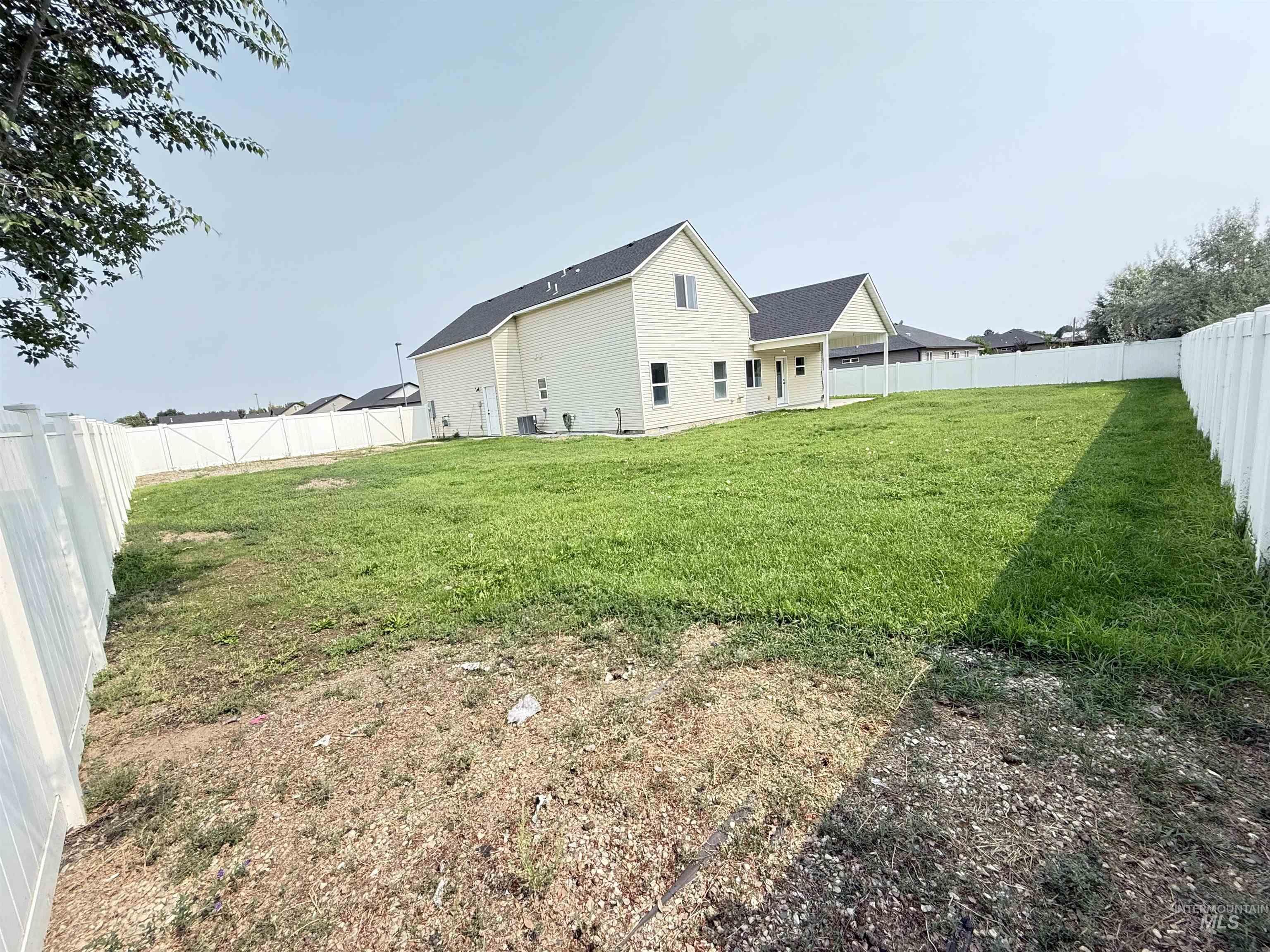 Back of property featuring a fenced backyard, a patio, and roof with shingles