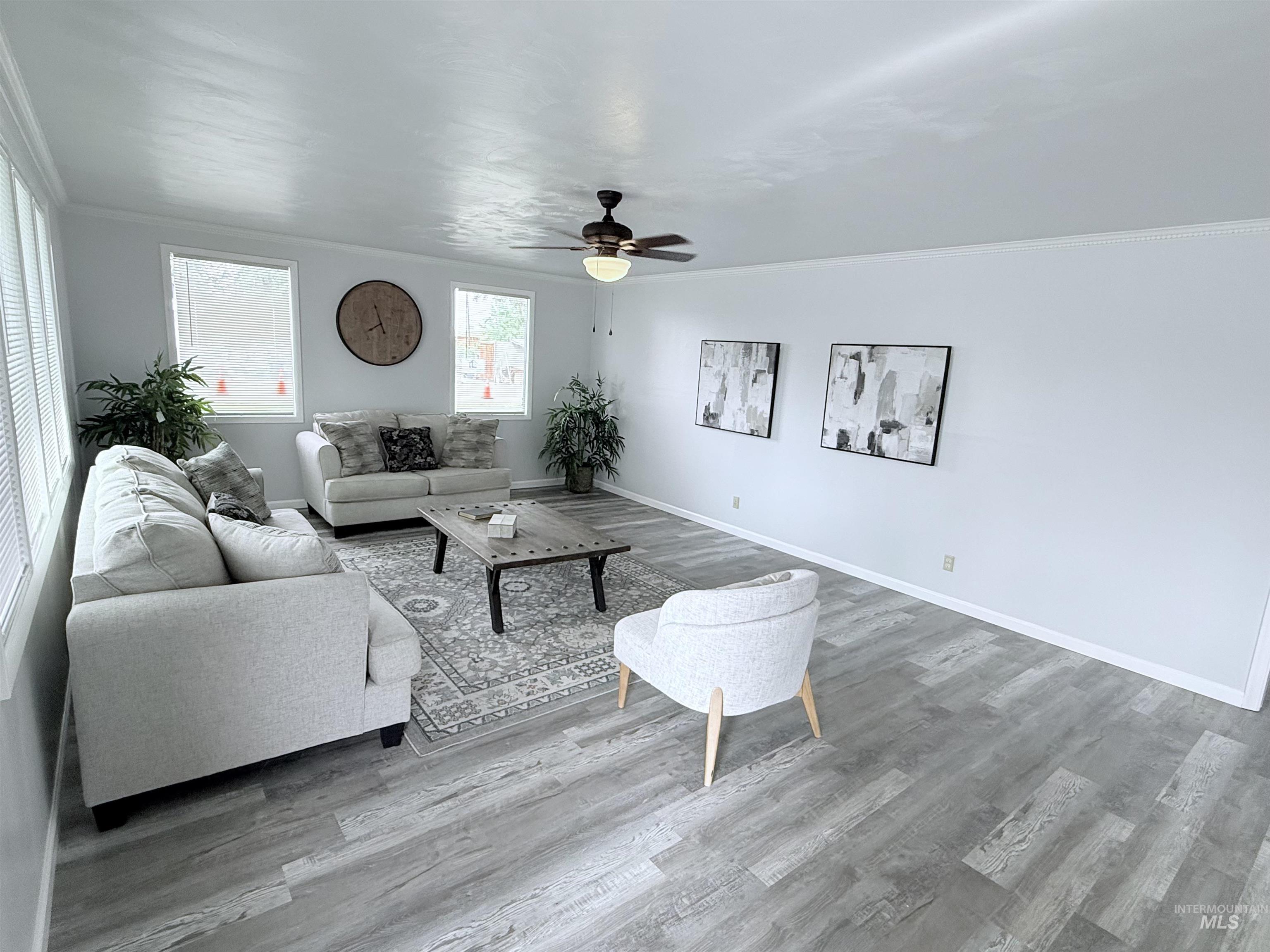 Living room featuring crown molding, a ceiling fan, and wood finished floors