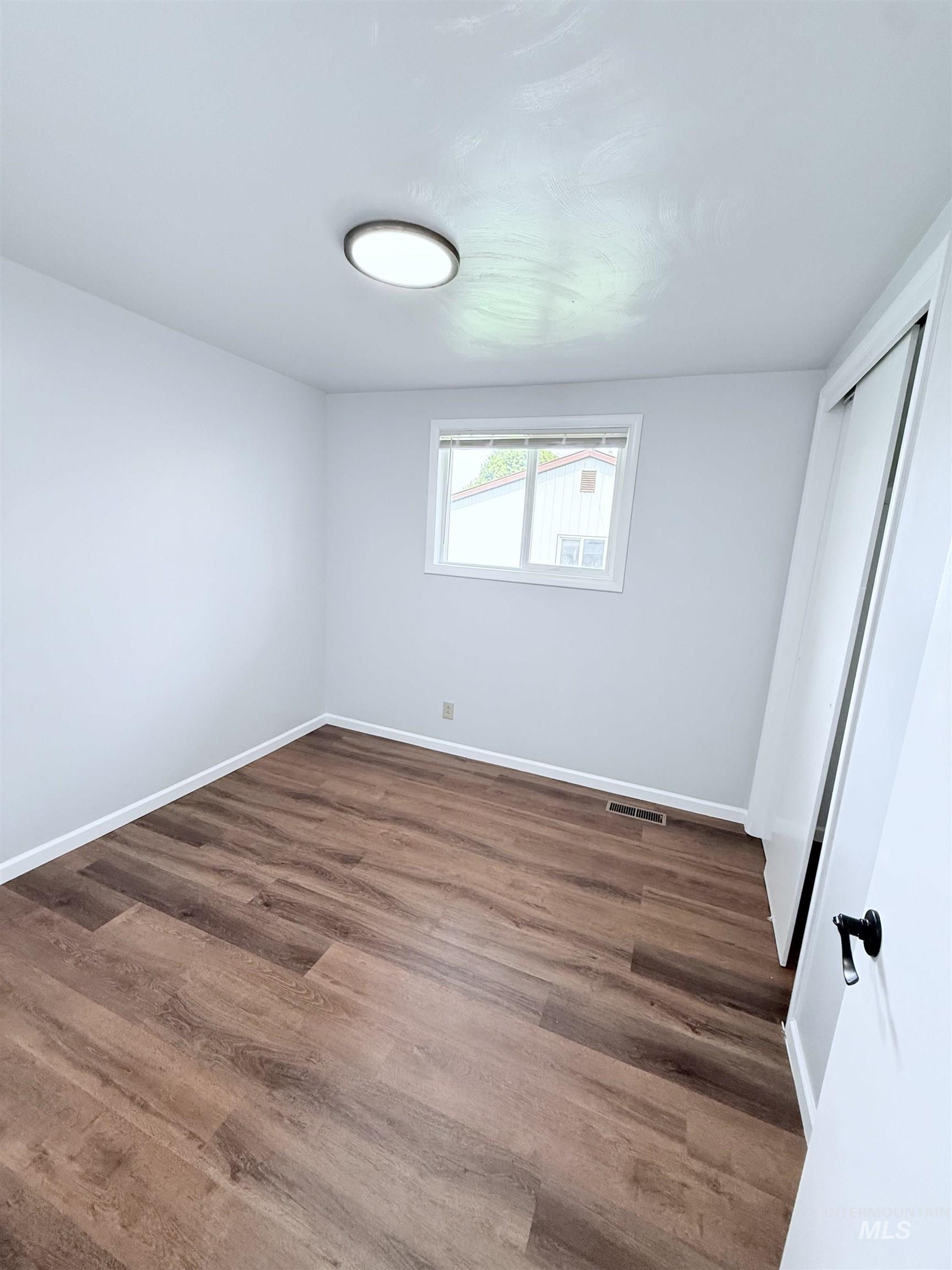 Unfurnished bedroom with wood finished floors and a closet