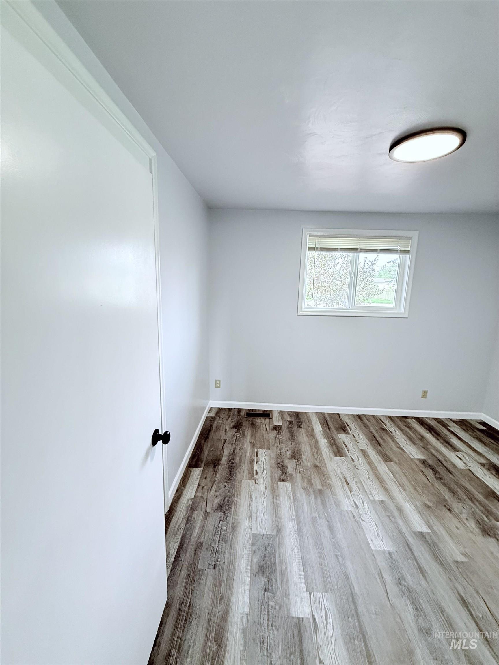 Spare room with wood finished floors and baseboards