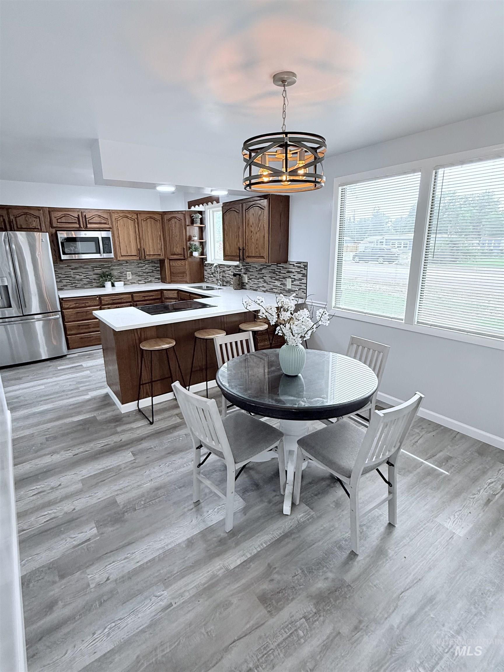 Dining space with light wood-style flooring and a chandelier
