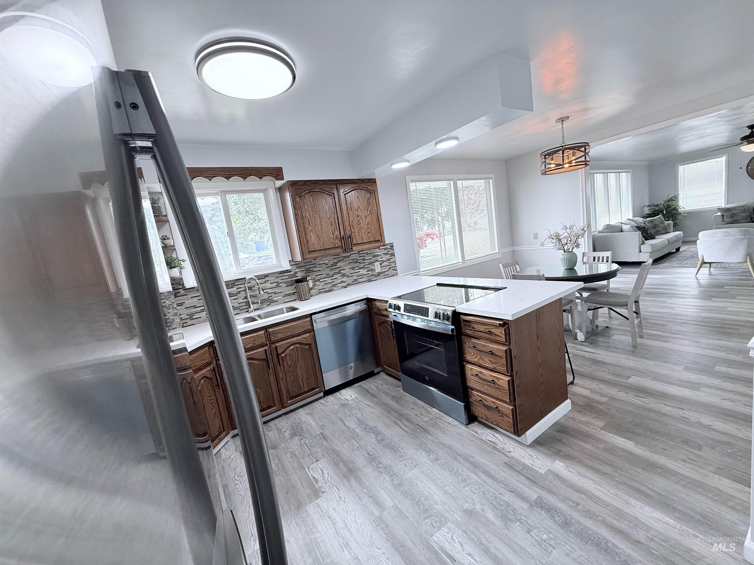 Kitchen with tasteful backsplash, stainless steel appliances, a peninsula, and plenty of natural light