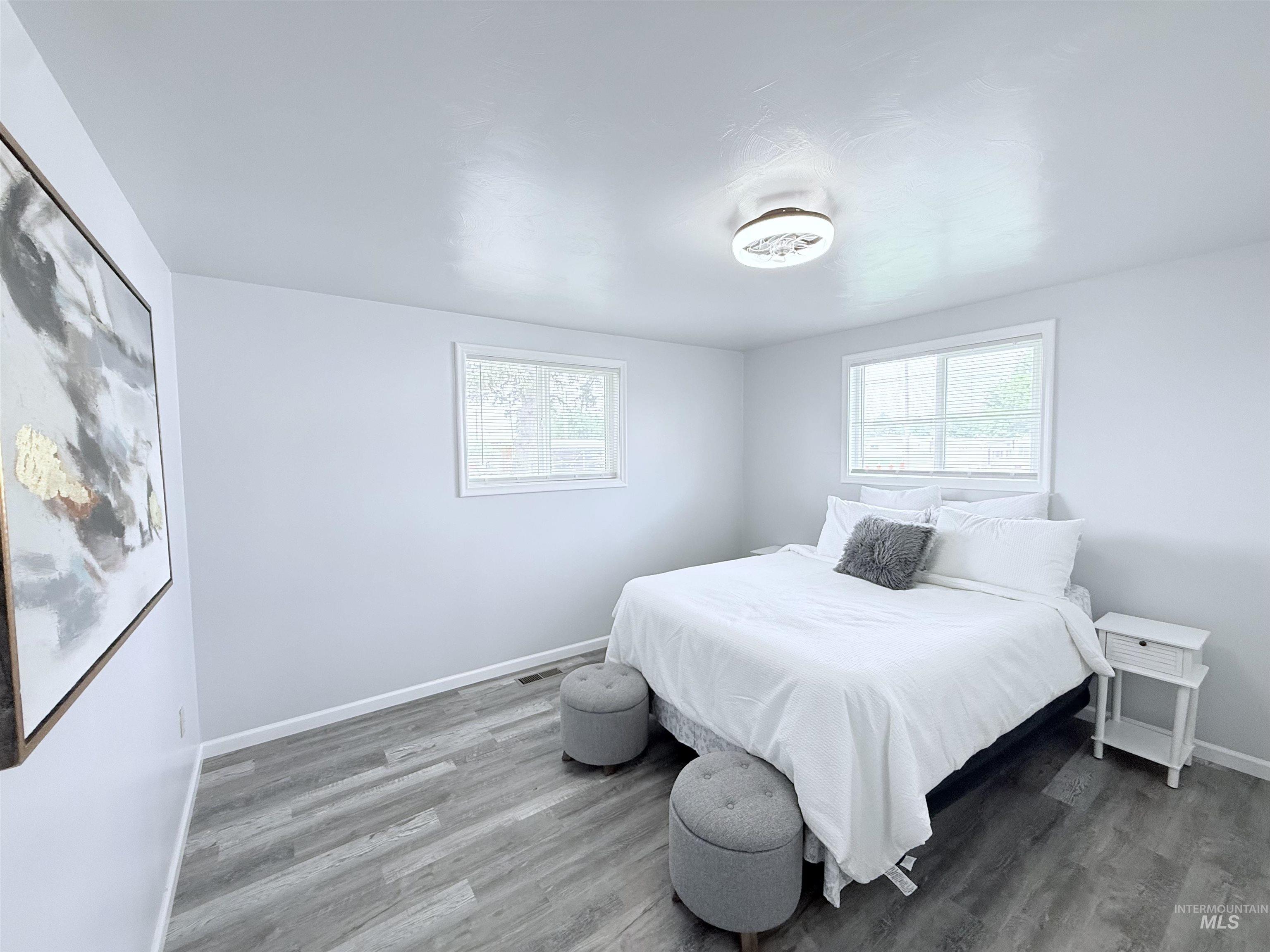 Bedroom with wood finished floors and baseboards