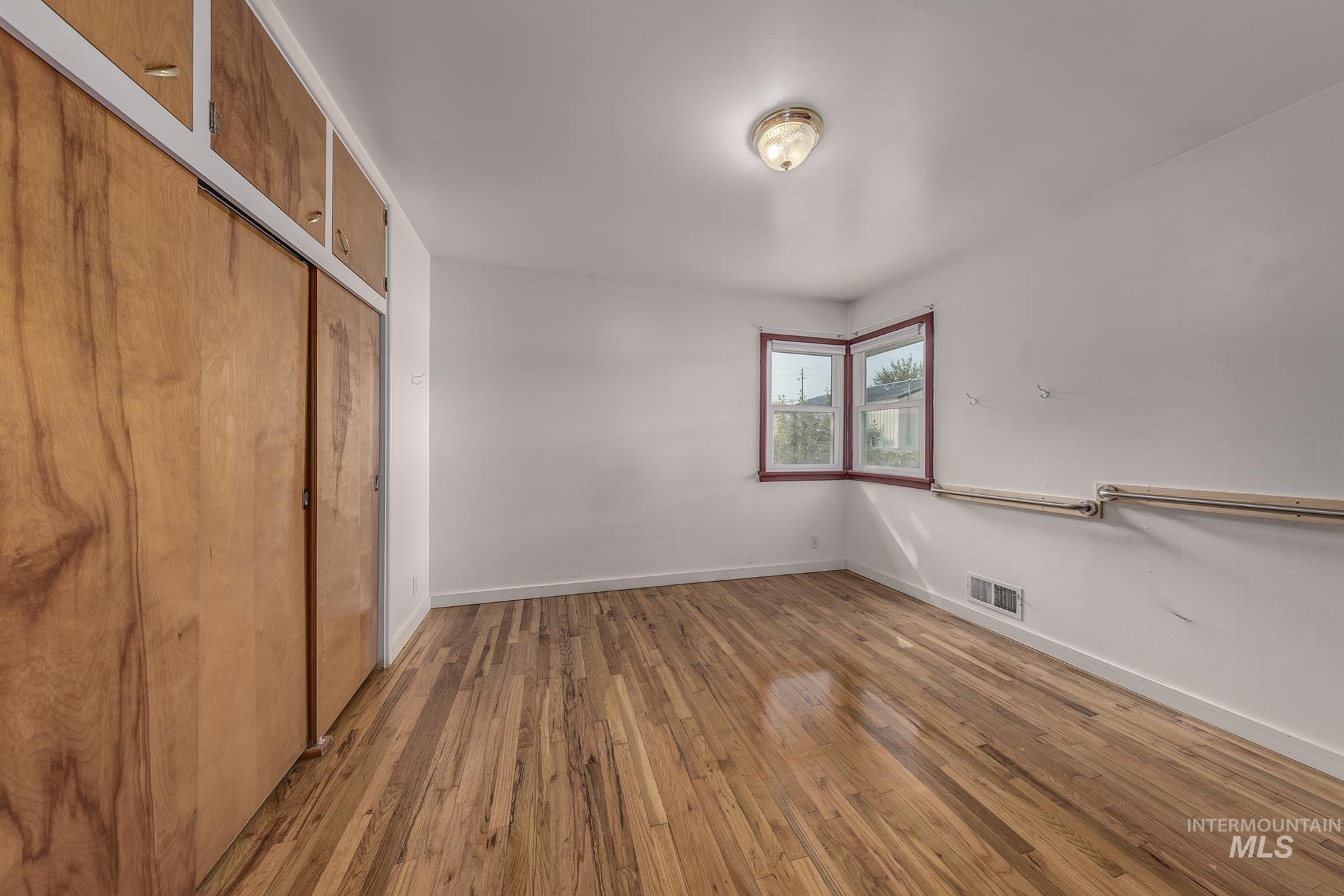 Unfurnished bedroom with light wood-style flooring and a closet