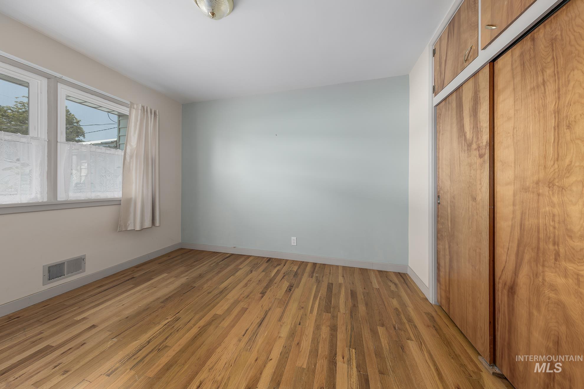 Unfurnished bedroom with a closet and light wood-style floors