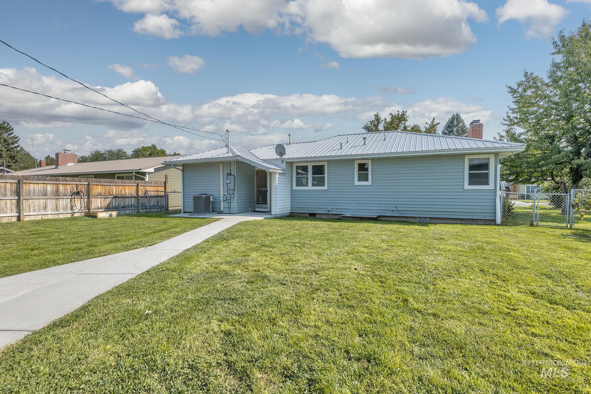 Rear view of house featuring a metal roof, a chimney, and a patio area