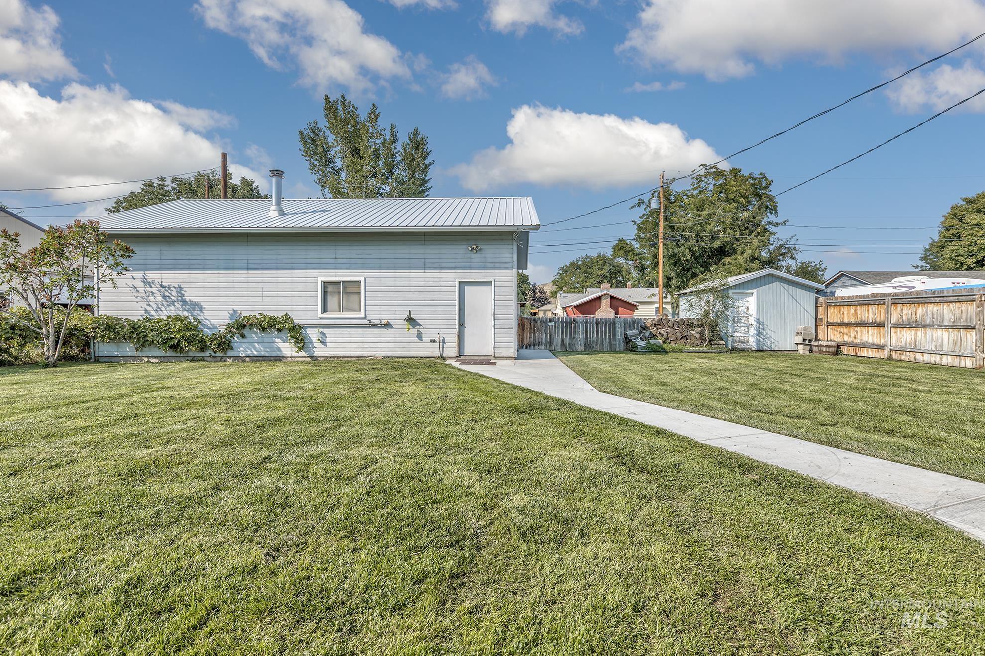 Rear view of property featuring a metal roof and a shed