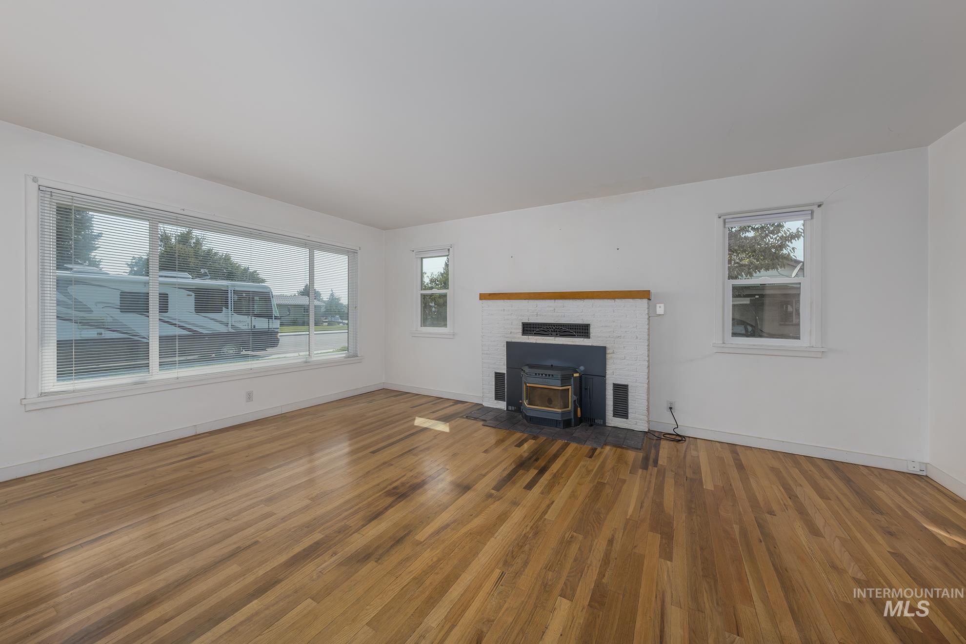 Unfurnished living room with a wood stove and light wood finished floors