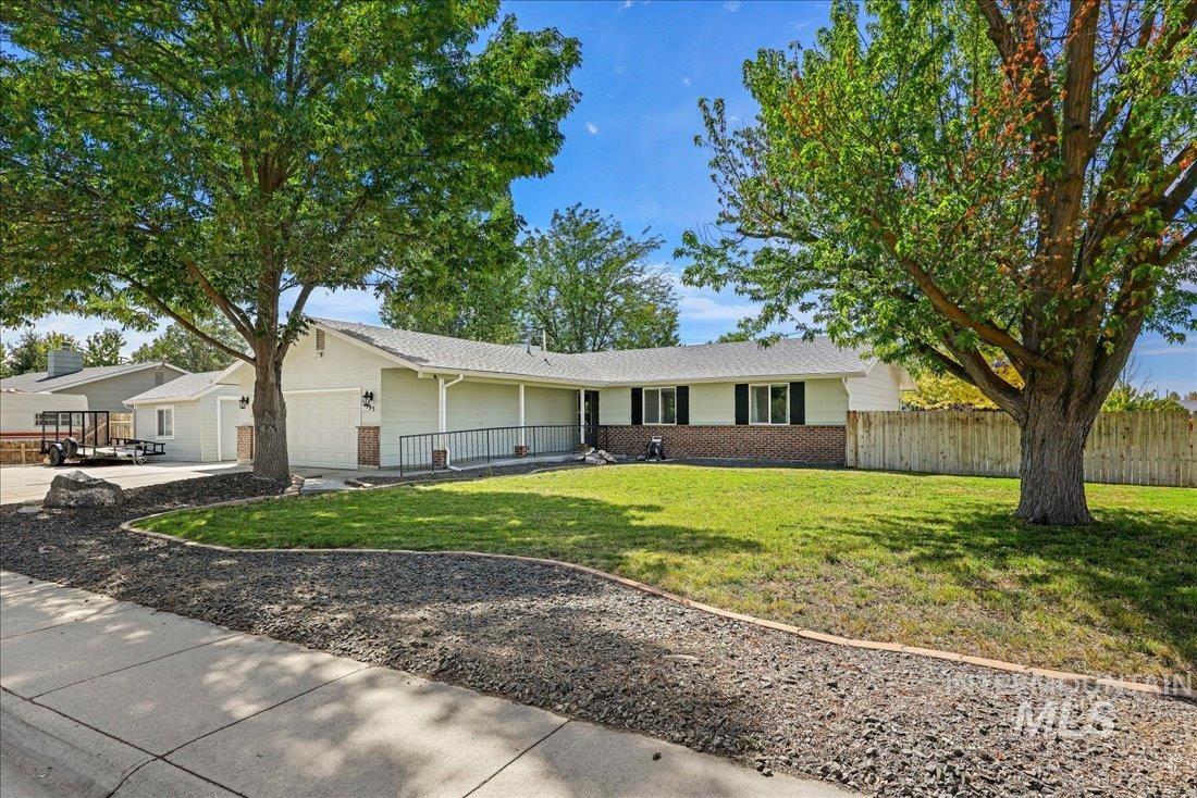 Single story home with an attached garage, brick siding, and driveway