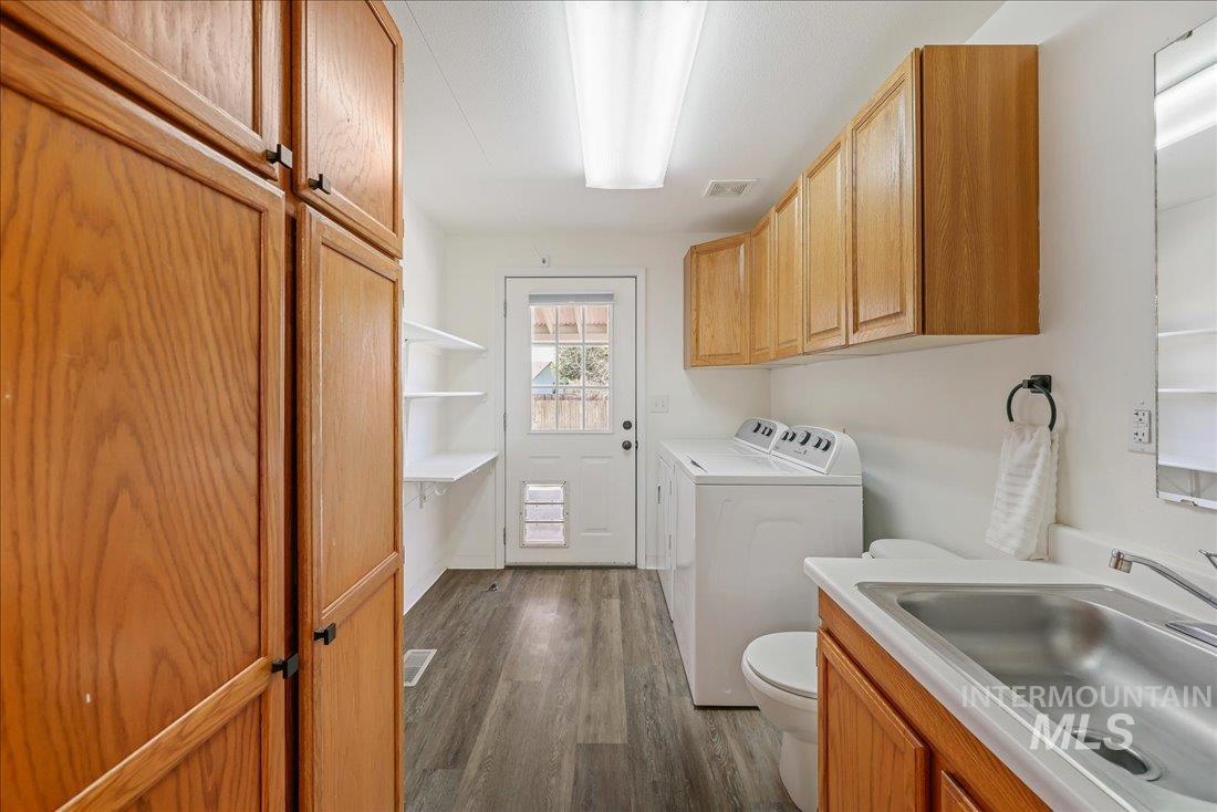 Washroom with washer and clothes dryer and dark wood-type flooring