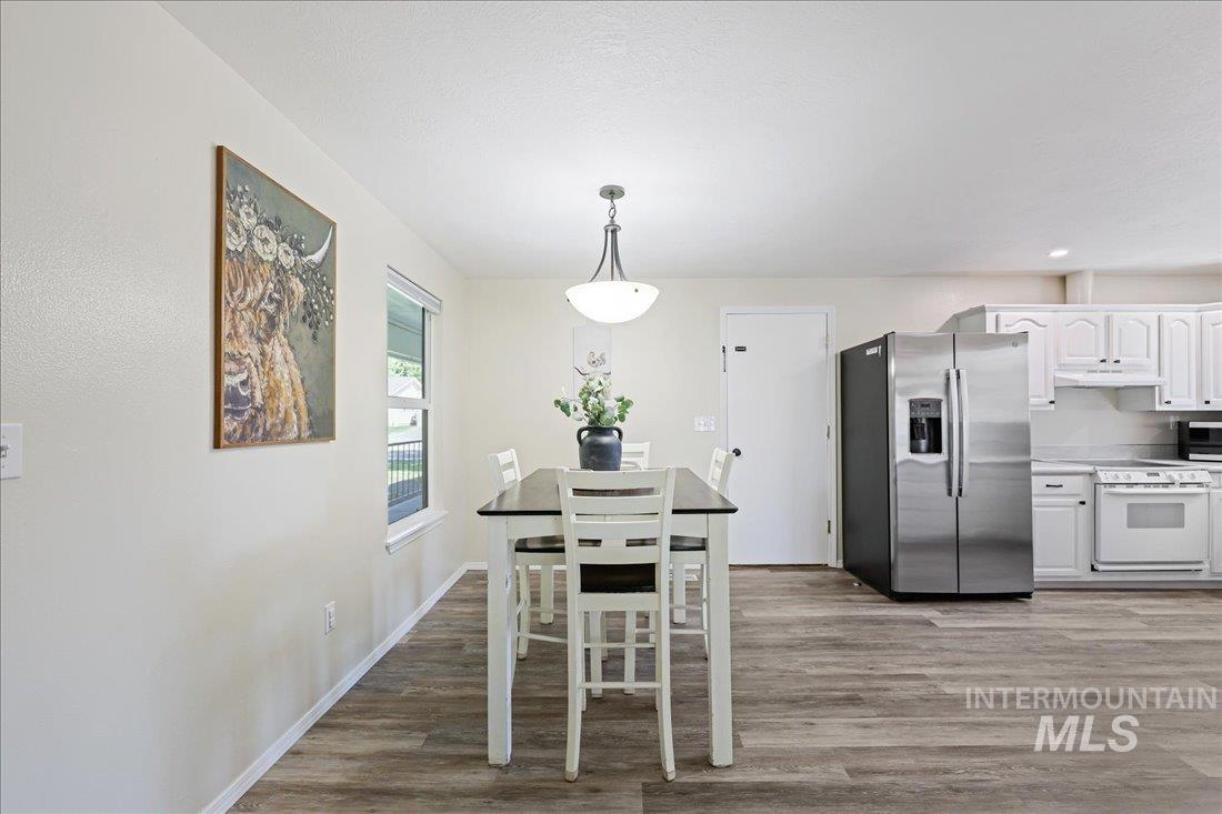 Dining space with light wood finished floors and recessed lighting