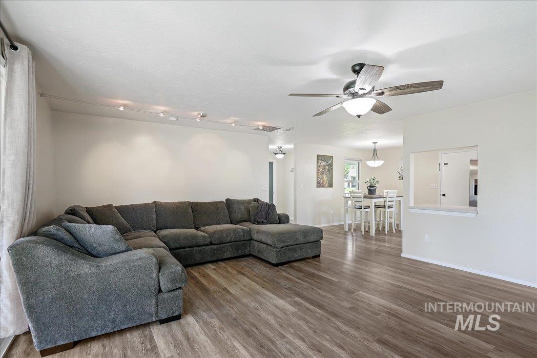 Living room featuring wood finished floors, ceiling fan, and a textured ceiling