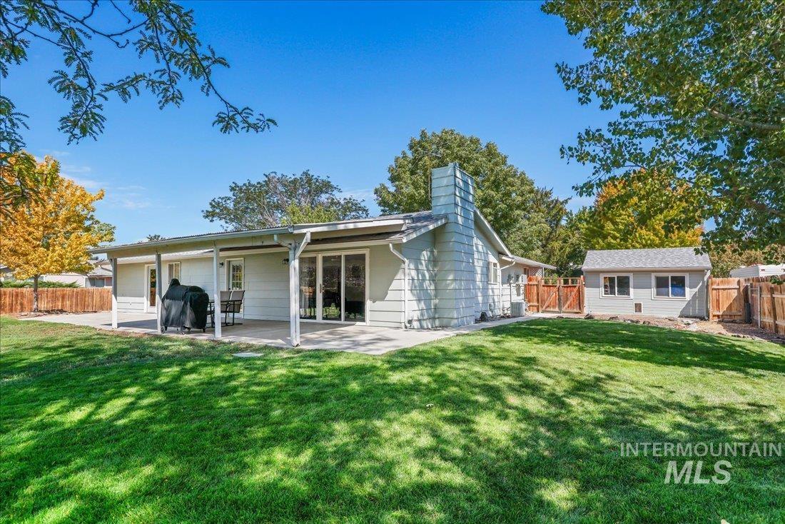 Back of property featuring a fenced backyard, a patio area, and a chimney