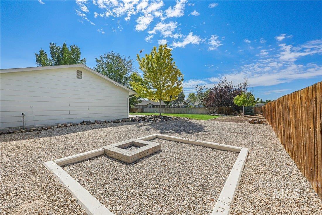 Fenced backyard with a fire pit