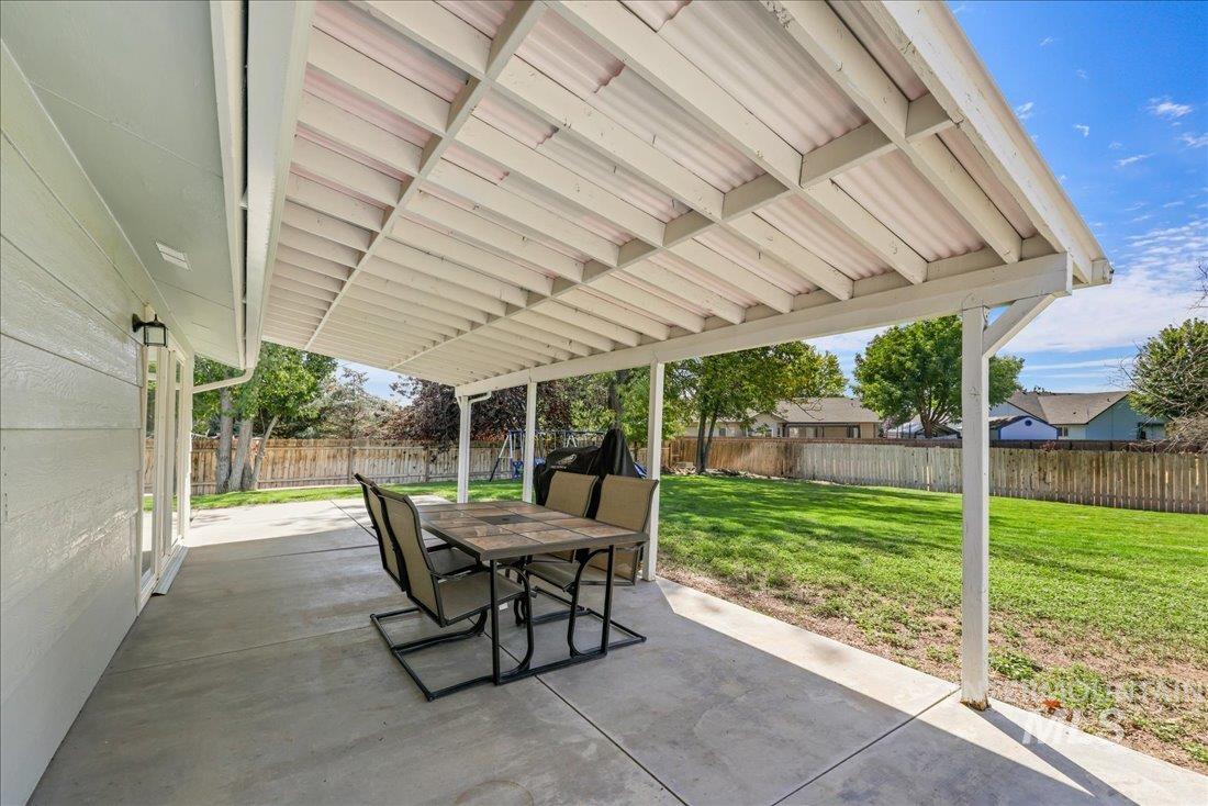 Fenced backyard with a patio and outdoor dining area