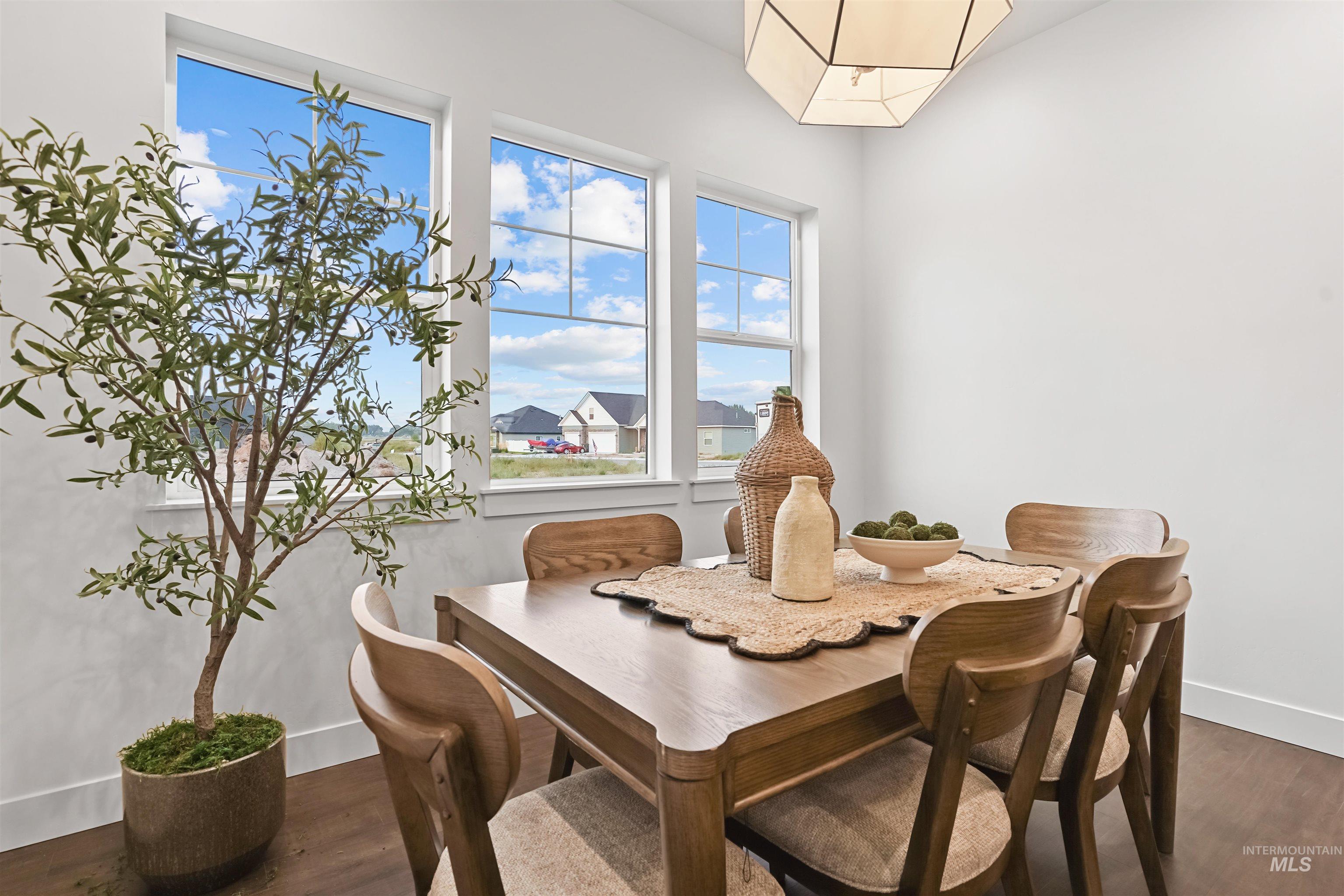 Dining room featuring dark wood-style flooring and baseboards
