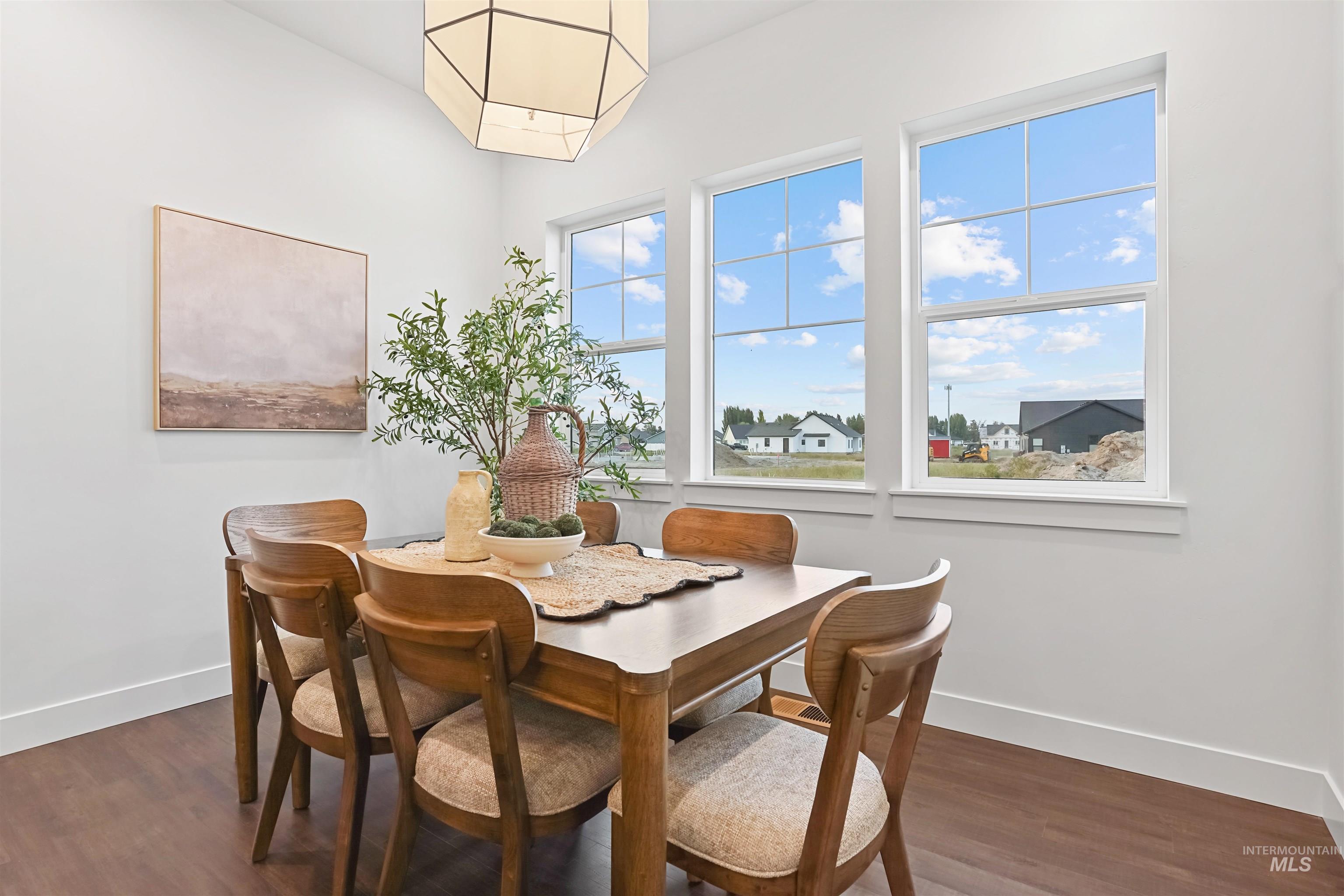 Dining space with baseboards and dark wood-style flooring
