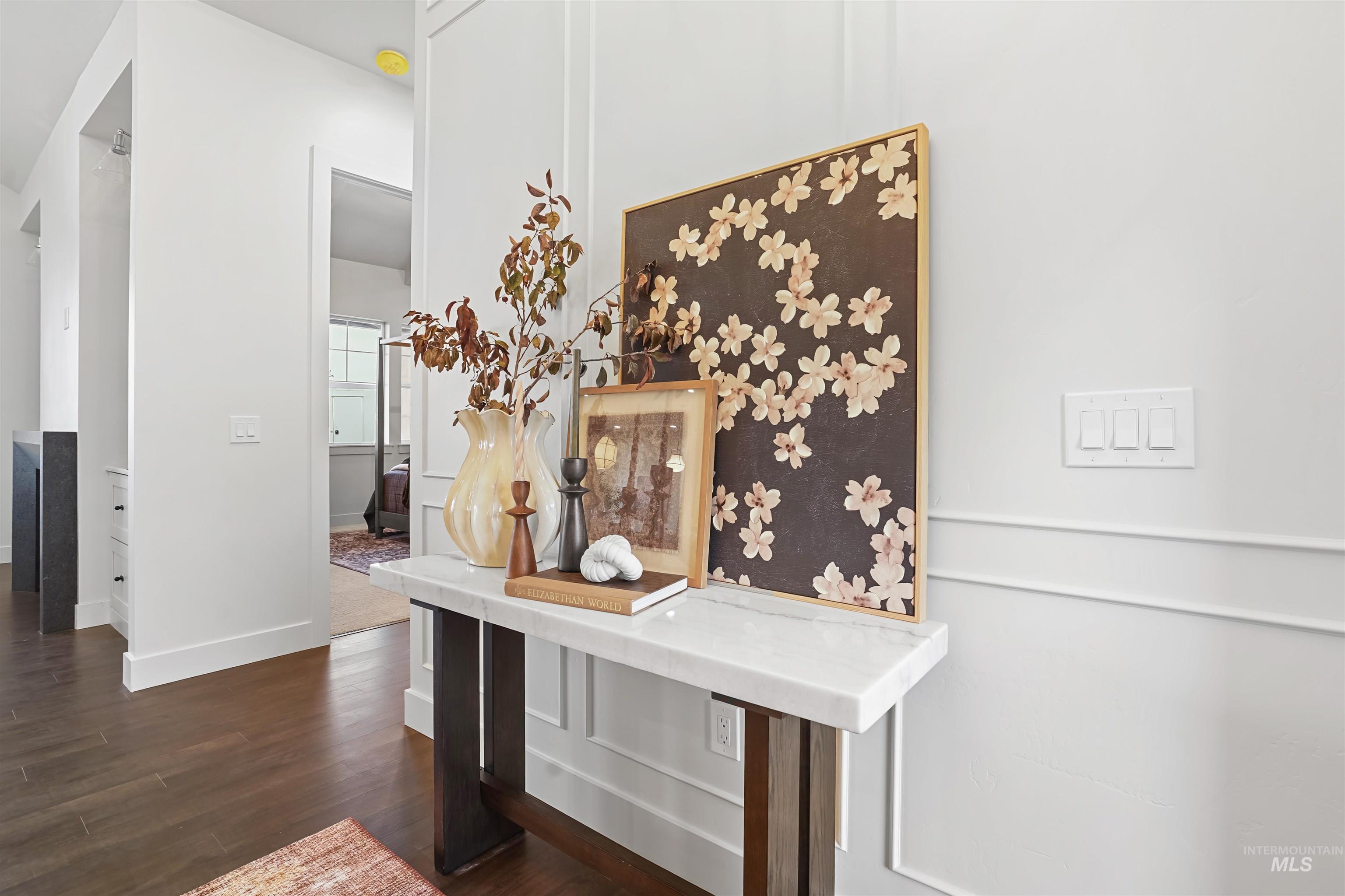 Hall with dark wood-style flooring and baseboards