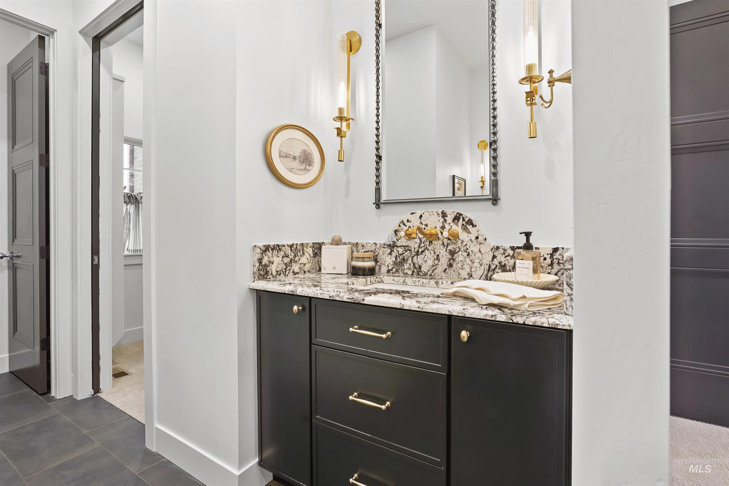 Bathroom featuring vanity and dark tile patterned floors
