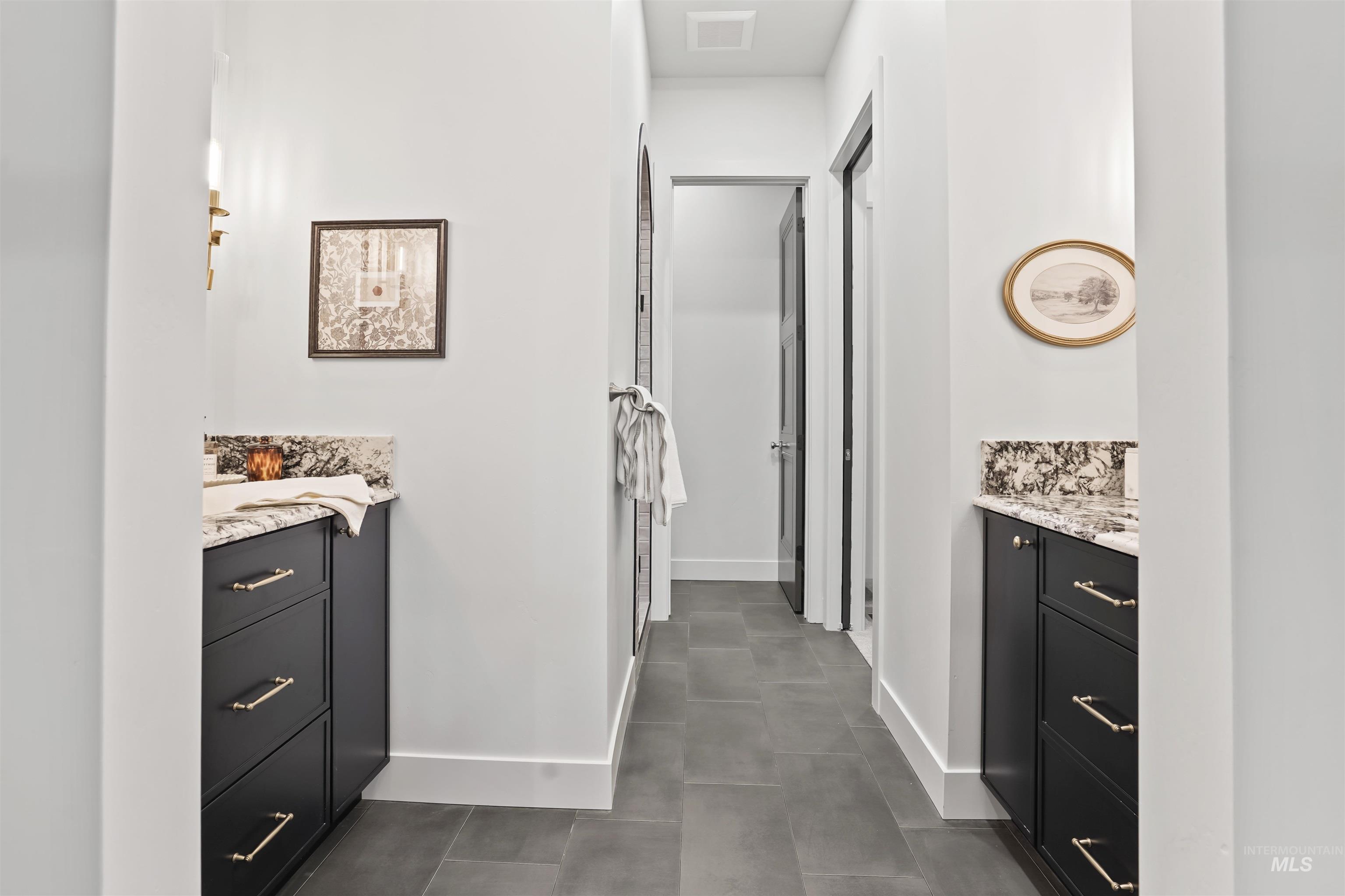 Corridor featuring baseboards and dark tile patterned floors