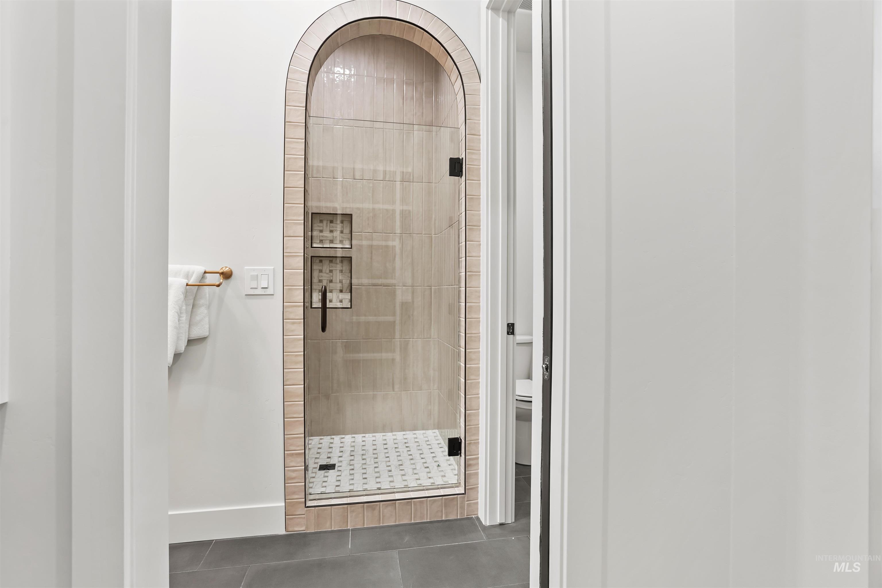 Full bath featuring tile patterned flooring and a shower stall
