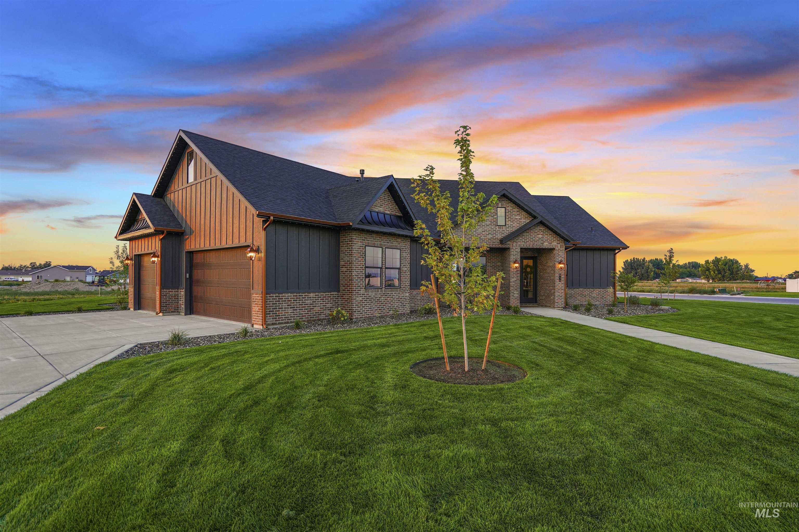View of front facade featuring driveway, a front lawn, a shingled roof, board and batten siding, and a garage