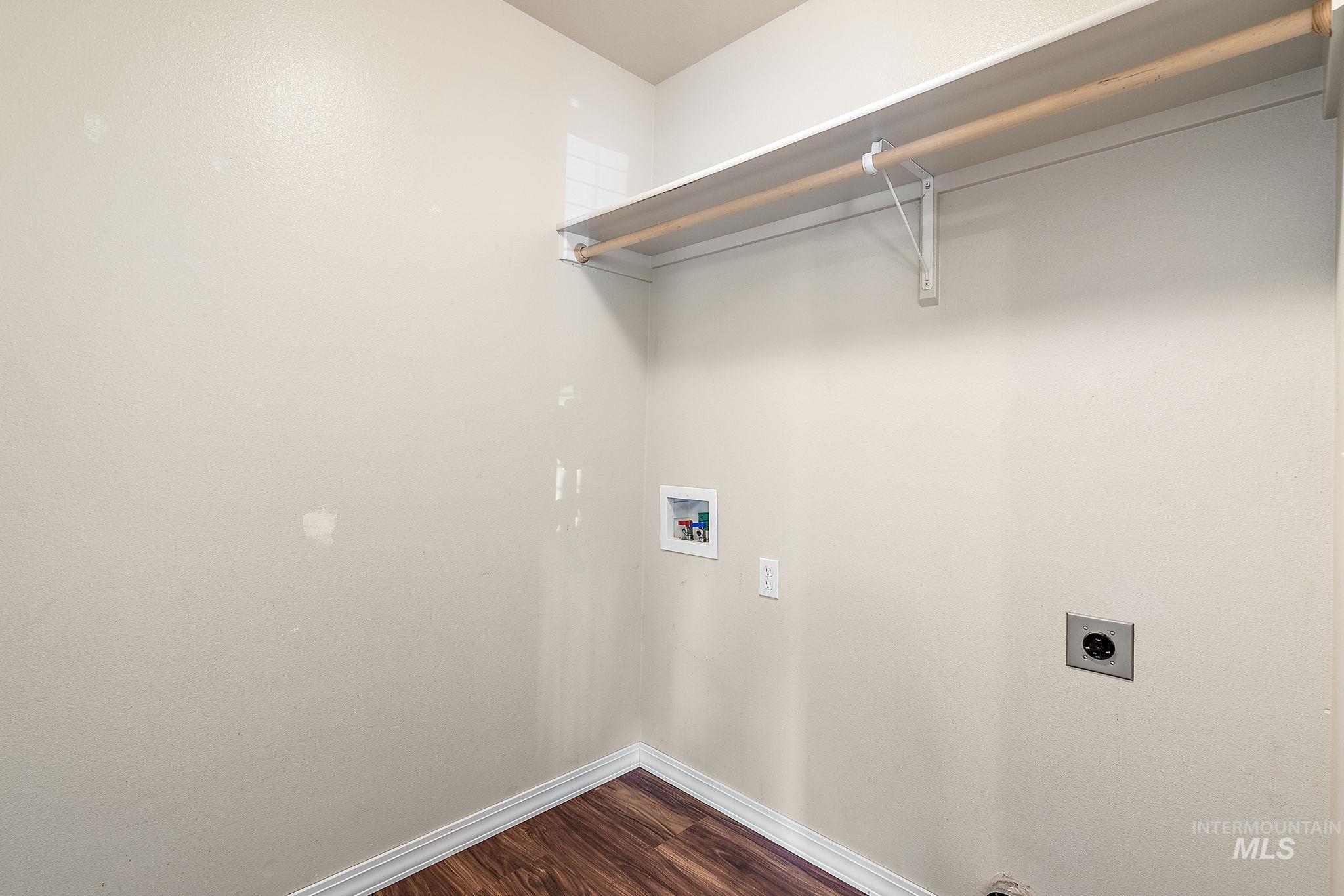Laundry room with dark wood-style flooring, hookup for a washing machine, and electric dryer hookup