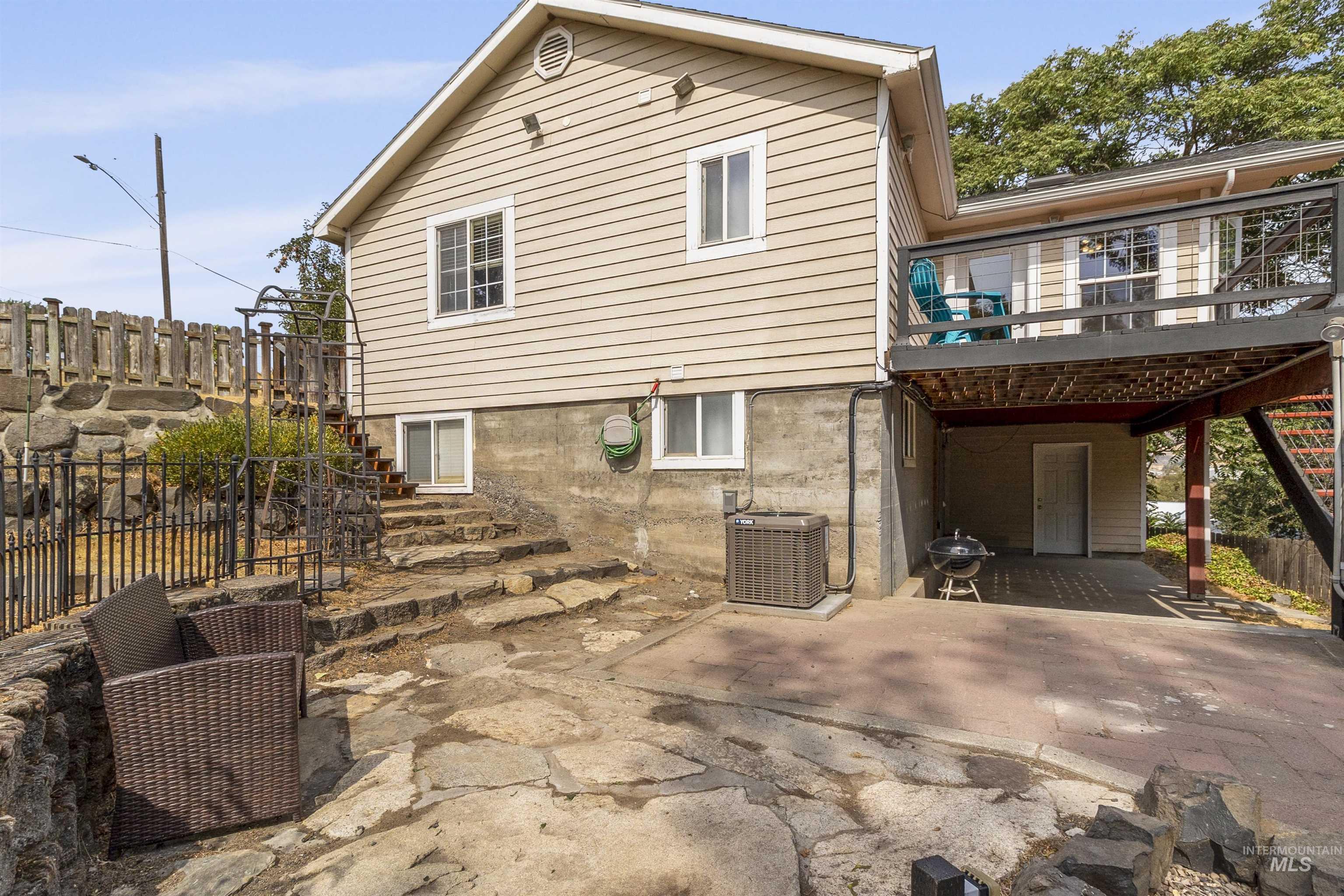 Rear view of property featuring a patio area, stairway, and a wooden deck