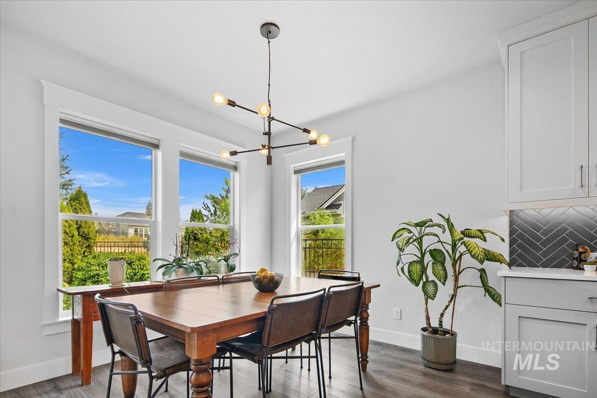 Dining space with dark wood-style flooring and a chandelier