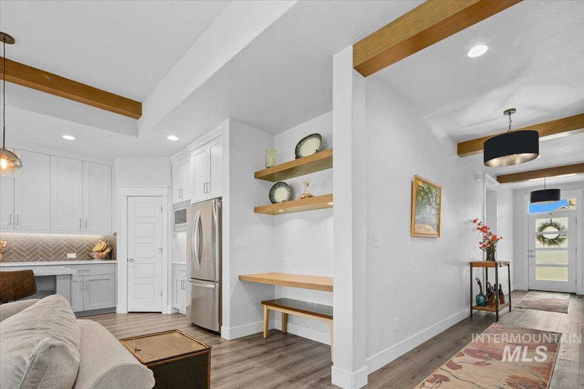 Interior space featuring beam ceiling, light wood-style flooring, and recessed lighting